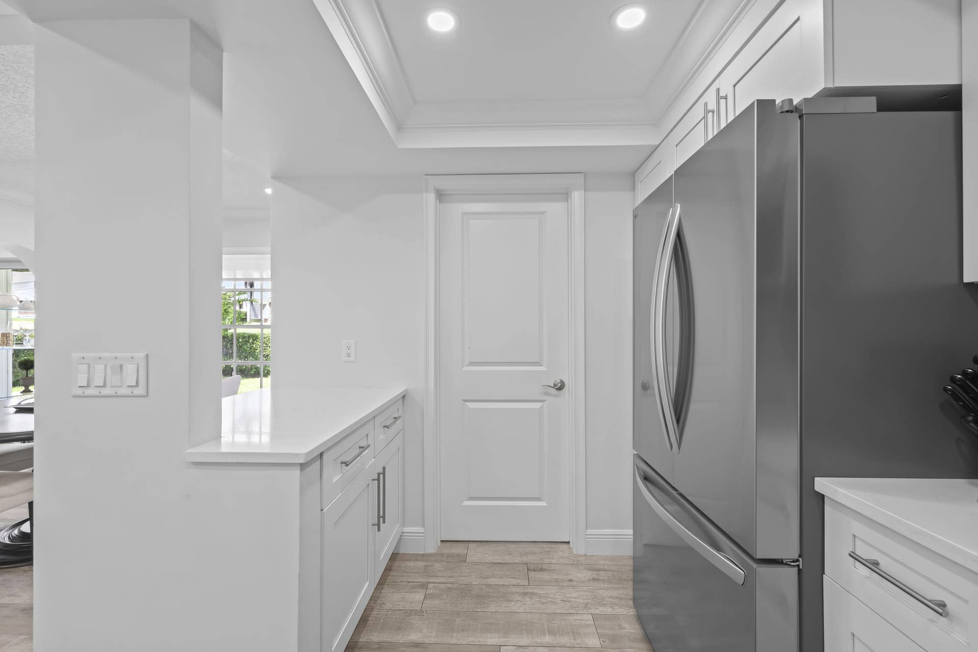 137 Clubhouse Boulevard, Atlantis, FL 33462 Kitchen featuring white cabinetry, quartz countertops, recessed ceiling lighting, stainless steel refrigerator, and wood-finish flooring