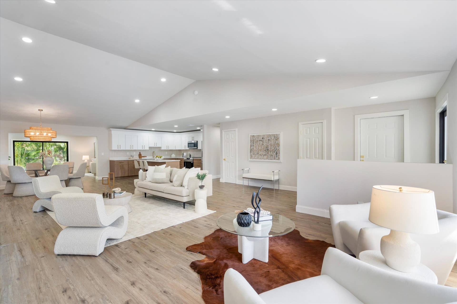 6111 WHITE OAK Lane, Tamarac, FL 33319 Vaulted ceilings, wood-finish flooring, recessed lighting, and white kitchen cabinetry