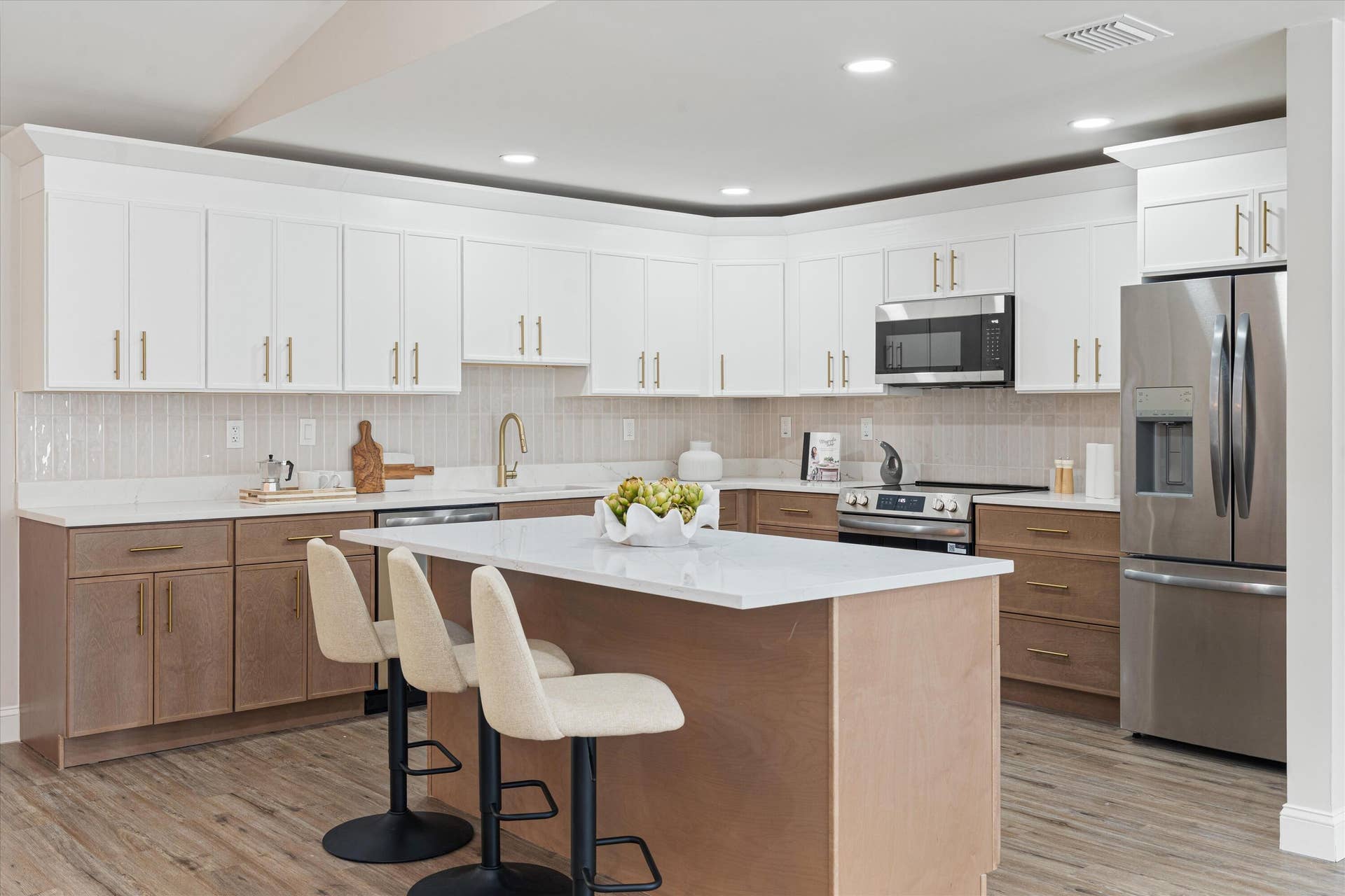 6111 WHITE OAK Lane, Tamarac, FL 33319 Kitchen featuring two-tone cabinetry, central island with seating space, stone-finish countertops, stainless steel appliances, and wood-finish flooring