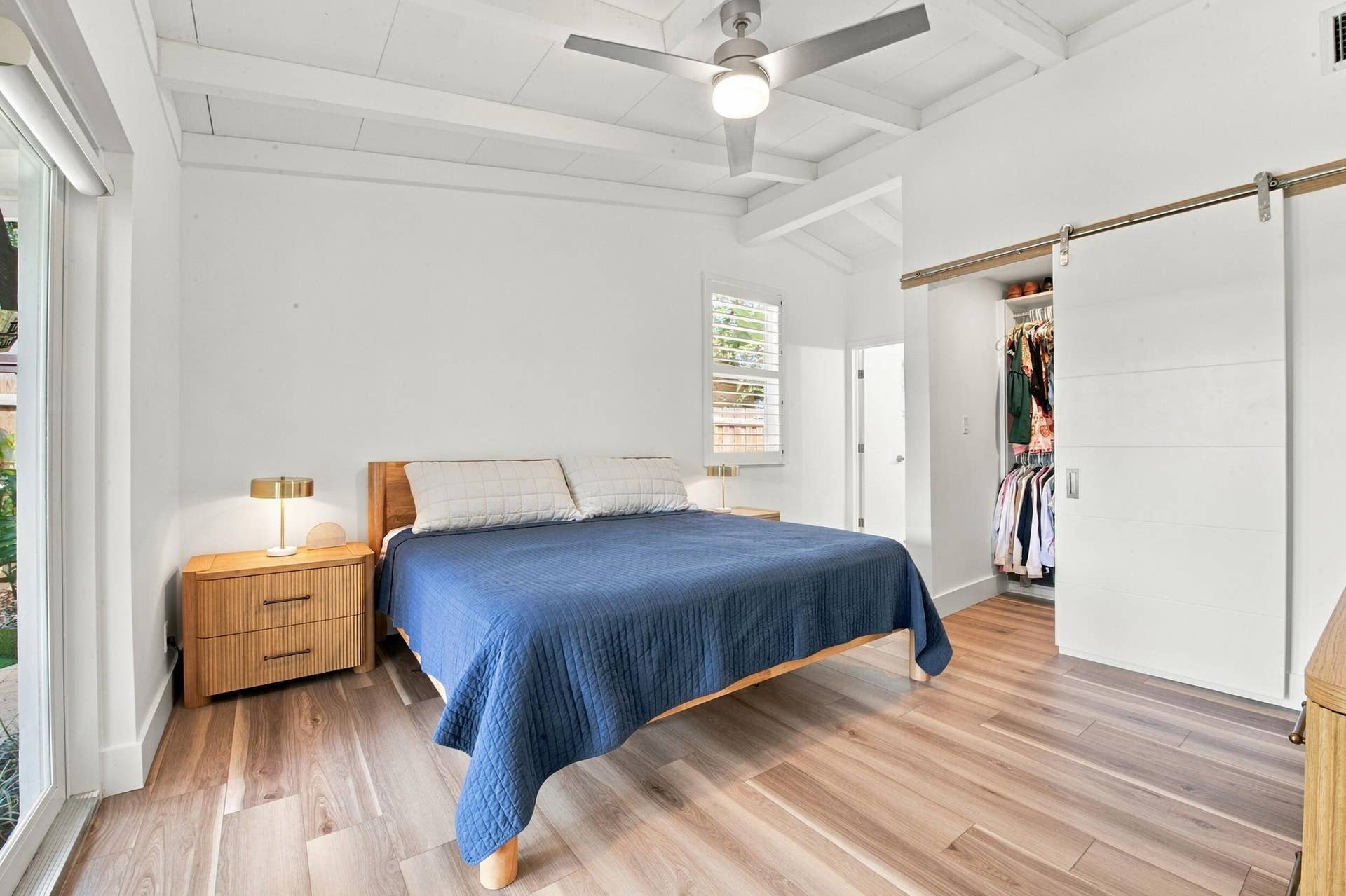 2449 KEY LARGO Lane, Fort Lauderdale, FL 33312 Wood-finish flooring, vaulted ceilings with exposed beams, sliding barn-style closet door, ceiling fan with integrated lighting, and plantation shutters