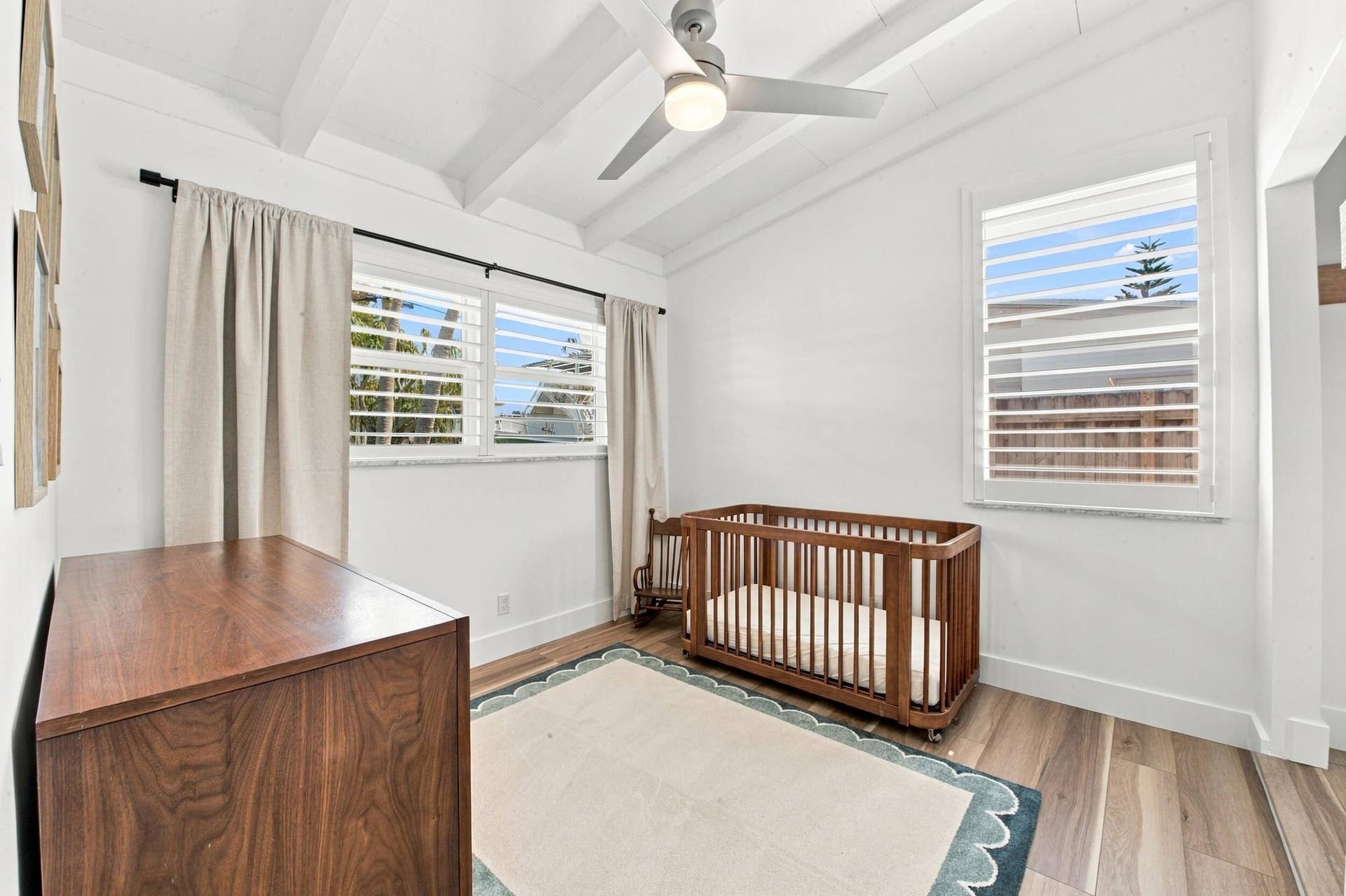 2449 KEY LARGO Lane, Fort Lauderdale, FL 33312 Wood-finish flooring, vaulted ceilings with exposed beams, three windows with plantation shutters, and a modern ceiling fan with integrated lighting