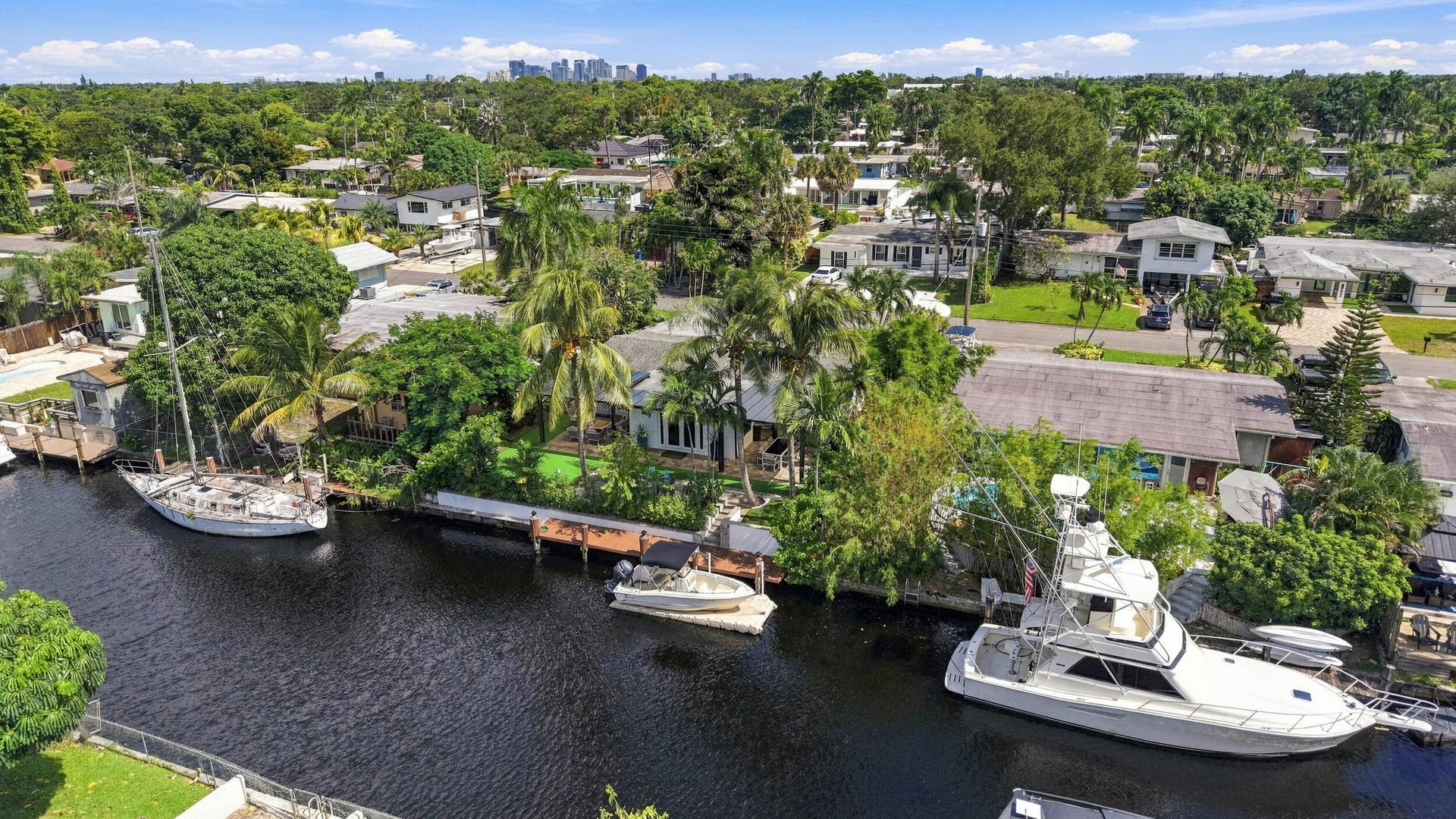 2449 KEY LARGO Lane, Fort Lauderdale, FL 33312 Waterfront property featuring a private bulkhead dock, mature landscaping, and direct canal access