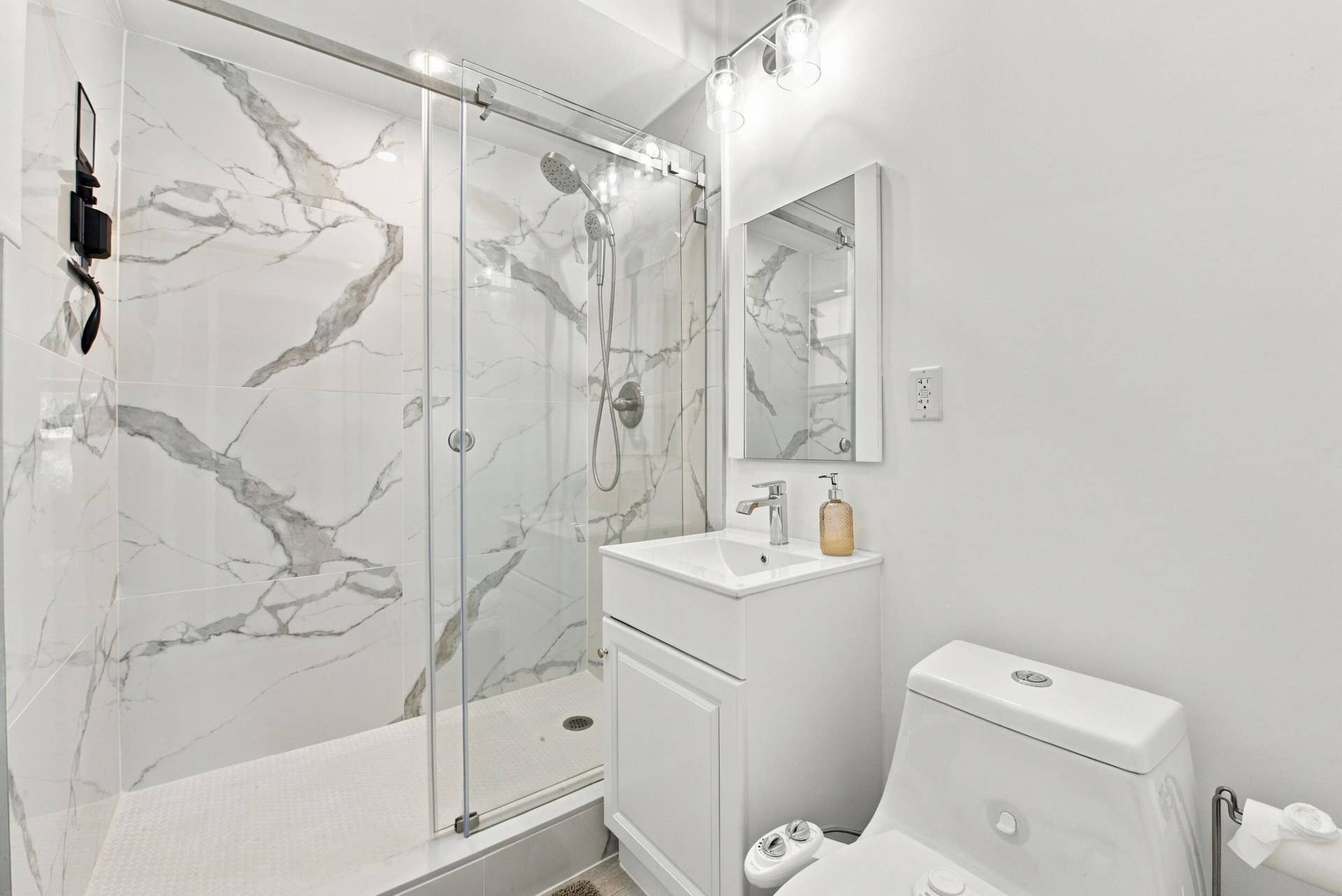 2449 KEY LARGO Lane, Fort Lauderdale, FL 33312 Walk-in shower with floor-to-ceiling stone-patterned tile, glass sliding enclosure, handheld shower fixture, white vanity with rectangular sink, and polished chrome hardware