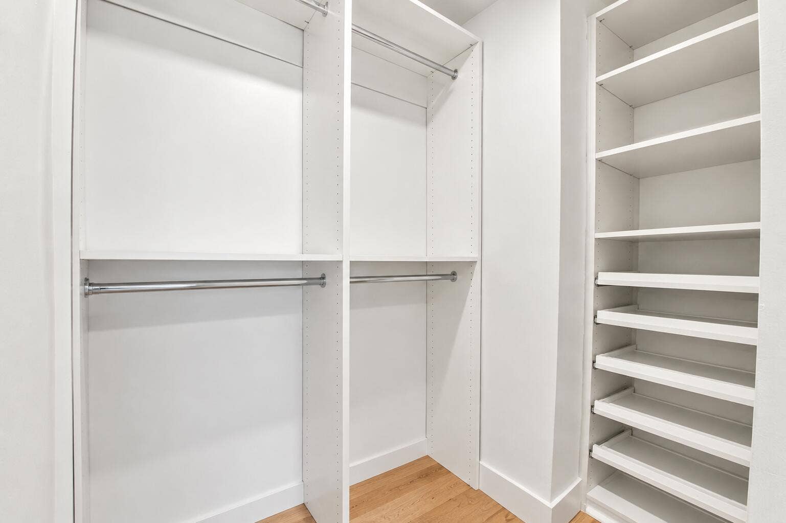 2449 KEY LARGO Lane, Fort Lauderdale, FL 33312 Custom closet system featuring white shelving, multiple hanging rods, and integrated pull-out drawers over wood-finish flooring