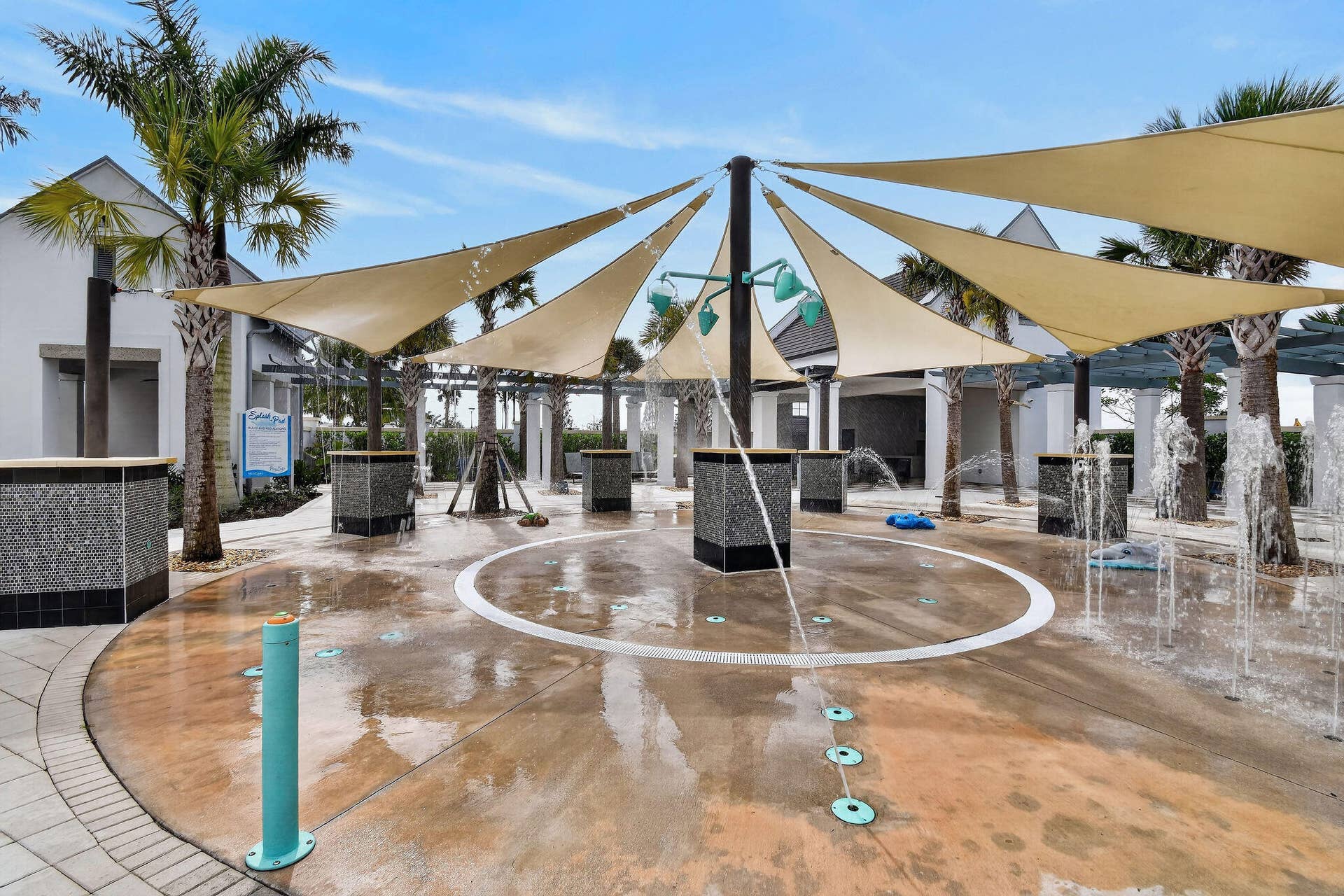 15811 Key Biscayne Lane, Westlake, FL 33470 Splash pad with multiple water features, shade sails, surrounding palm trees, and tiled accent pillars