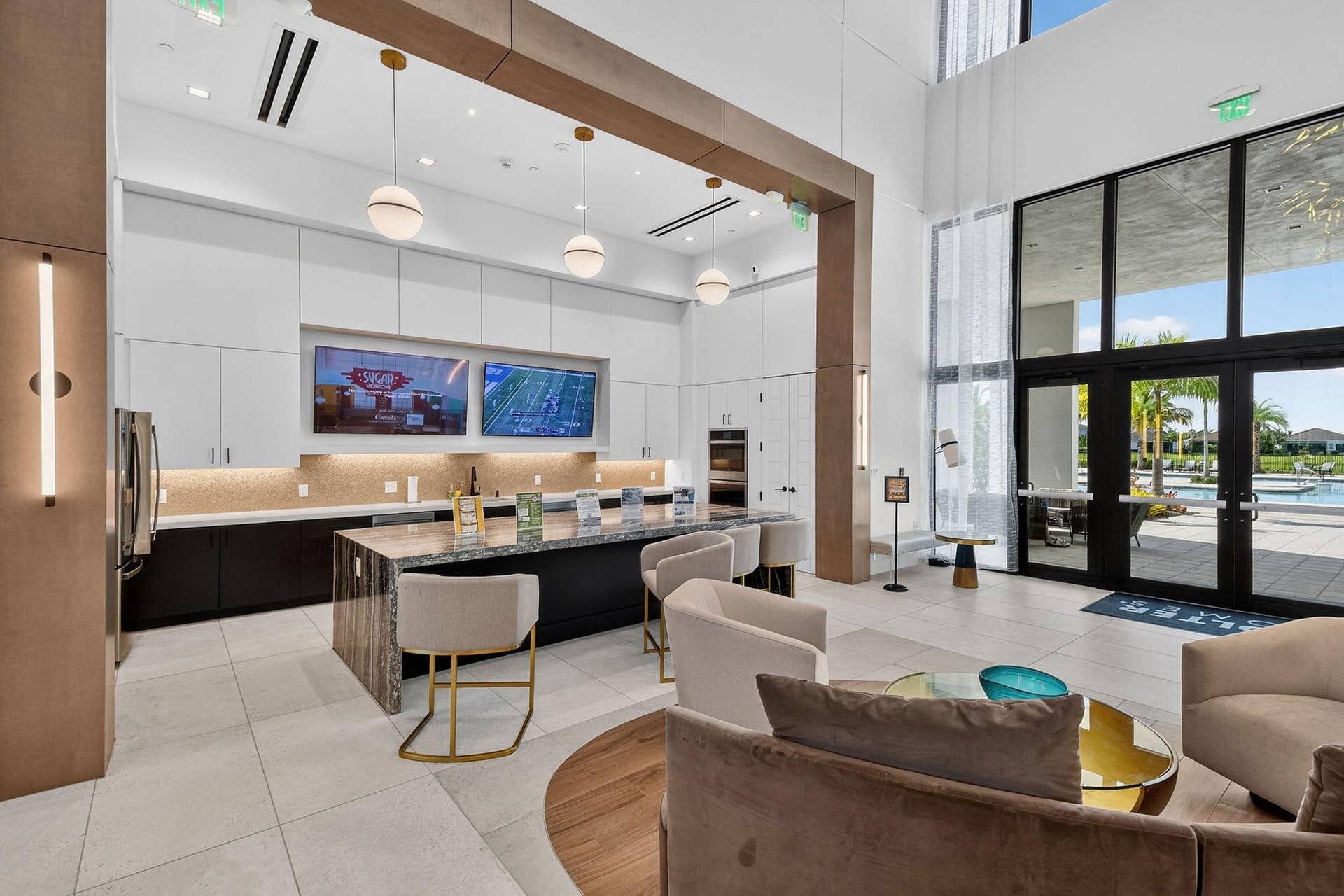 15811 Key Biscayne Lane, Westlake, FL 33470 Spacious common area featuring an expansive counter with integrated seating, dual wall-mounted displays, and floor-to-ceiling windows