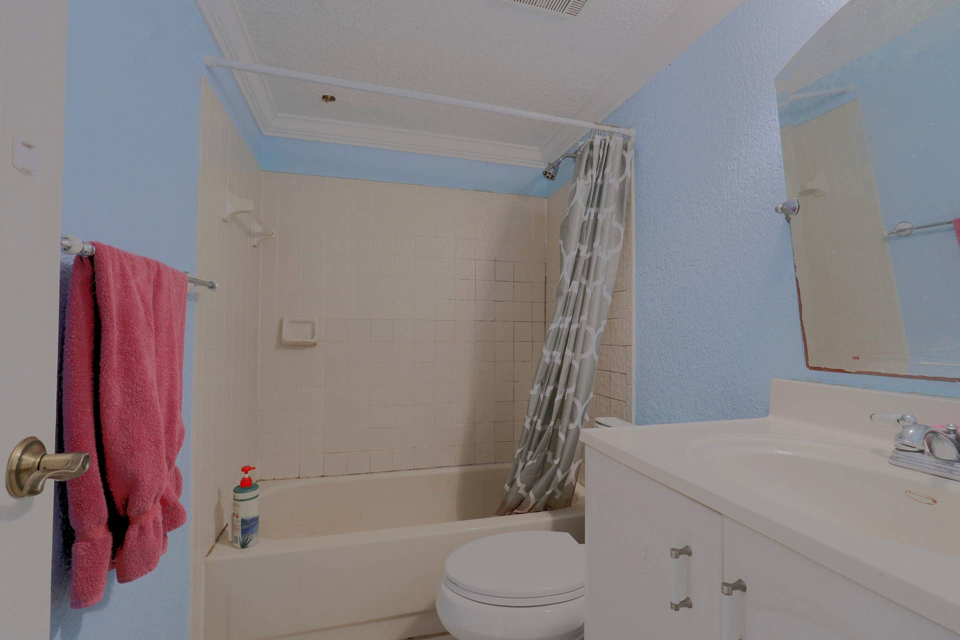 9853 NW 3RD Court, #7, Plantation, FL 33324 Bathroom featuring a tub-shower combination with tile surround, white vanity cabinet with a molded sink, and a wall-mounted mirror