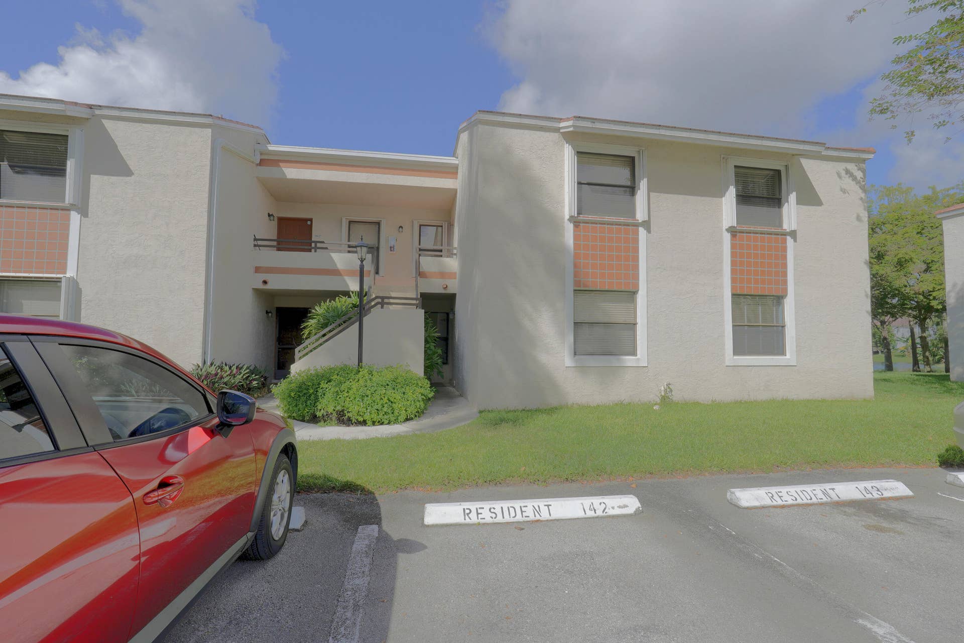 9853 NW 3RD Court, #7, Plantation, FL 33324 Two-story stucco exterior featuring tile accents, sliding windows, and designated resident parking