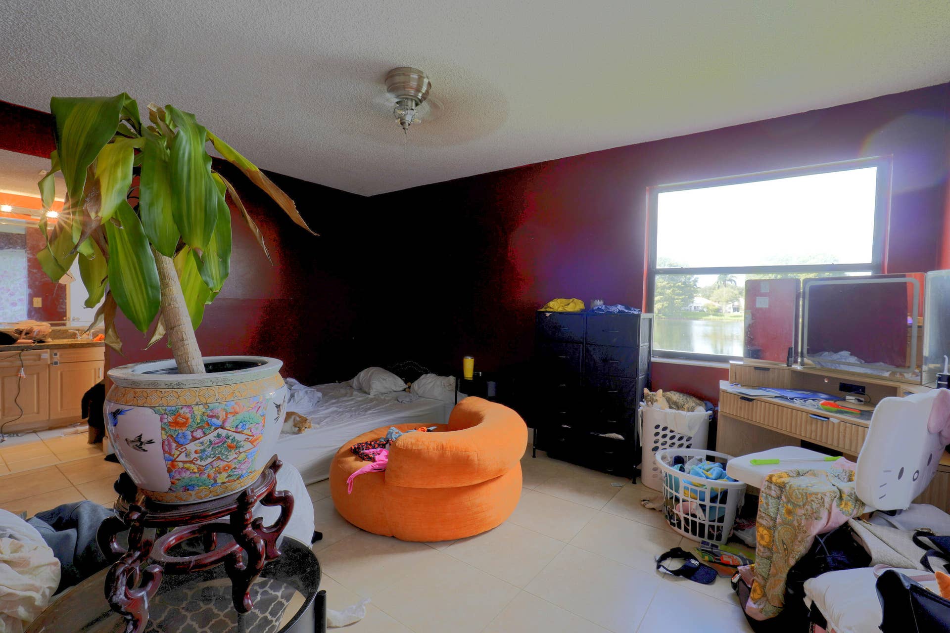 9853 NW 3RD Court, #7, Plantation, FL 33324 Spacious room featuring large window with exterior water frontage, neutral tile flooring, and a ceiling-mounted light fixture