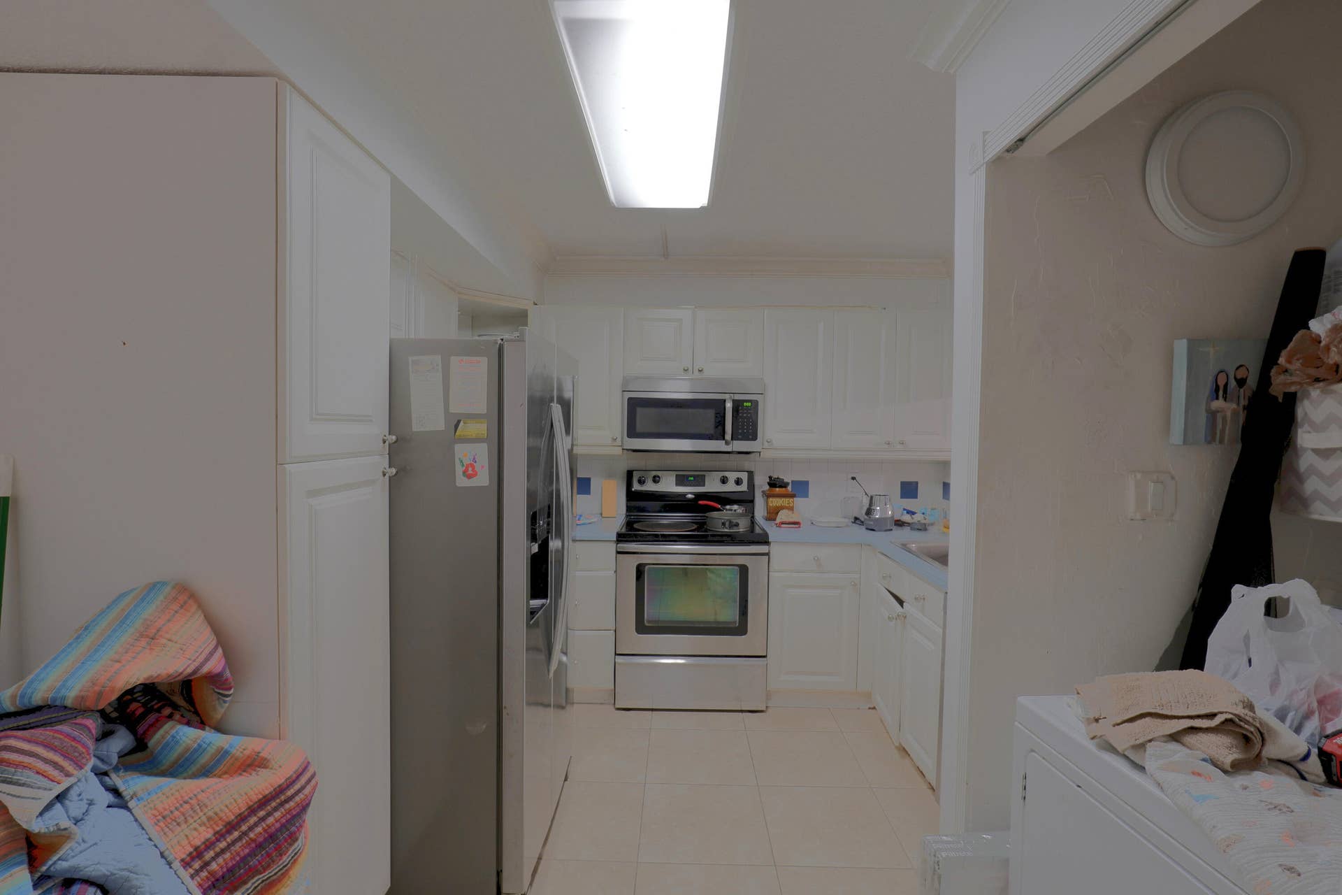 9853 NW 3RD Court, #7, Plantation, FL 33324 Kitchen featuring white cabinetry, stainless steel appliances, tiled backsplash, and light-toned flooring