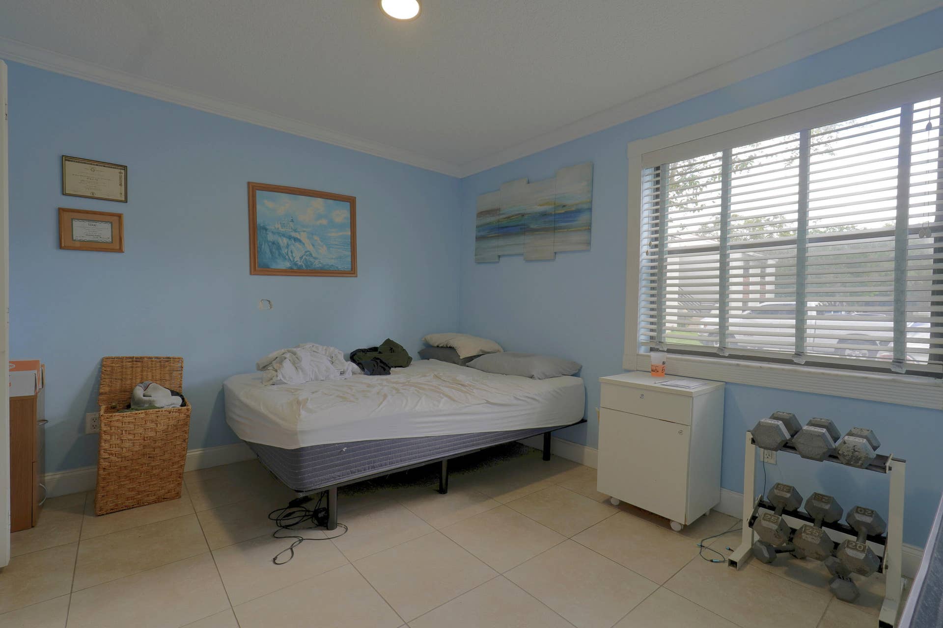 9853 NW 3RD Court, #7, Plantation, FL 33324 Light-filled room featuring large-format tile flooring, crown molding, and horizontal slat window blinds