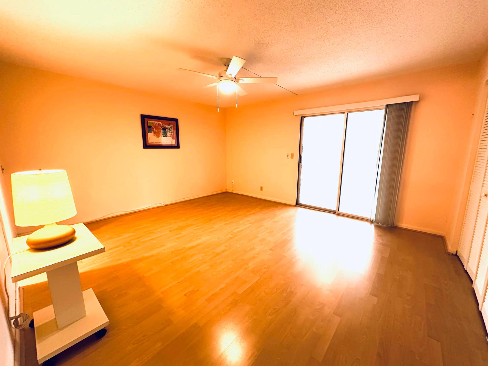 4011 NEWPORT G, Deerfield Beach, FL 33442 Laminate flooring, ceiling fan with integrated lighting, and glass sliding doors with vertical blinds