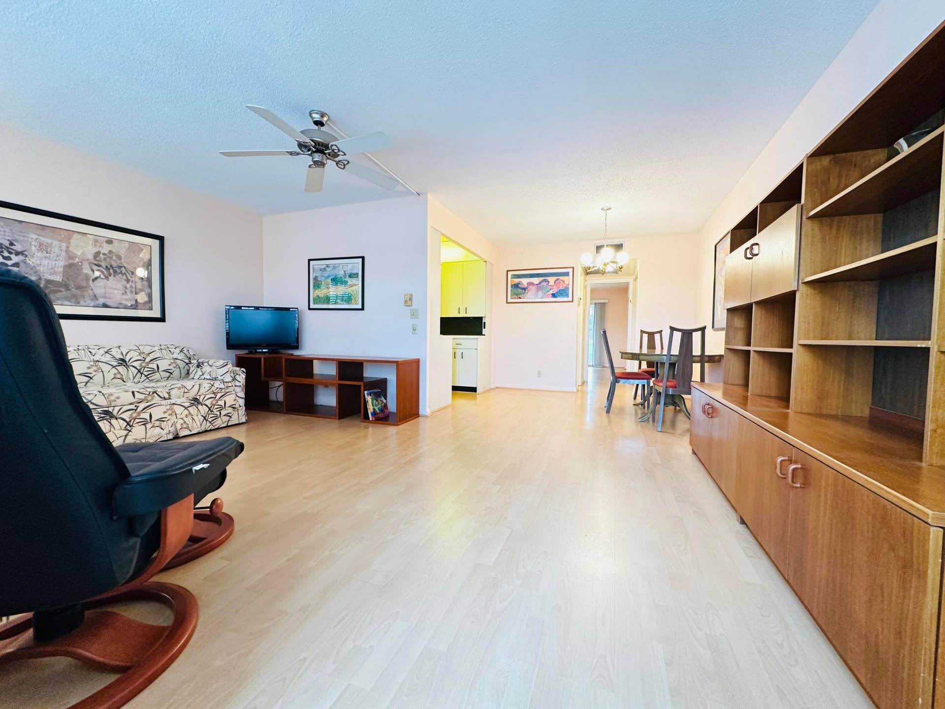 4011 NEWPORT G, Deerfield Beach, FL 33442 Open-concept living space featuring laminate flooring, furnished, and a ceiling fan with integrated lighting