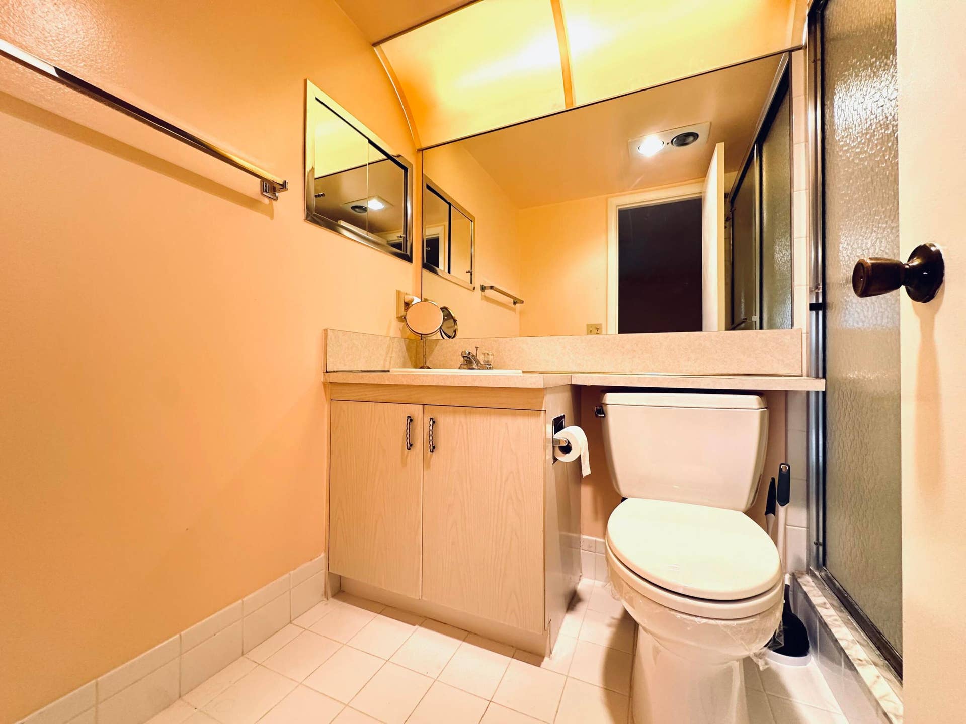 4011 NEWPORT G, Deerfield Beach, FL 33442 Bathroom vanity with integrated countertop and sink, wall-spanning vanity mirror, porcelain tile flooring, and a glass-enclosed shower stall