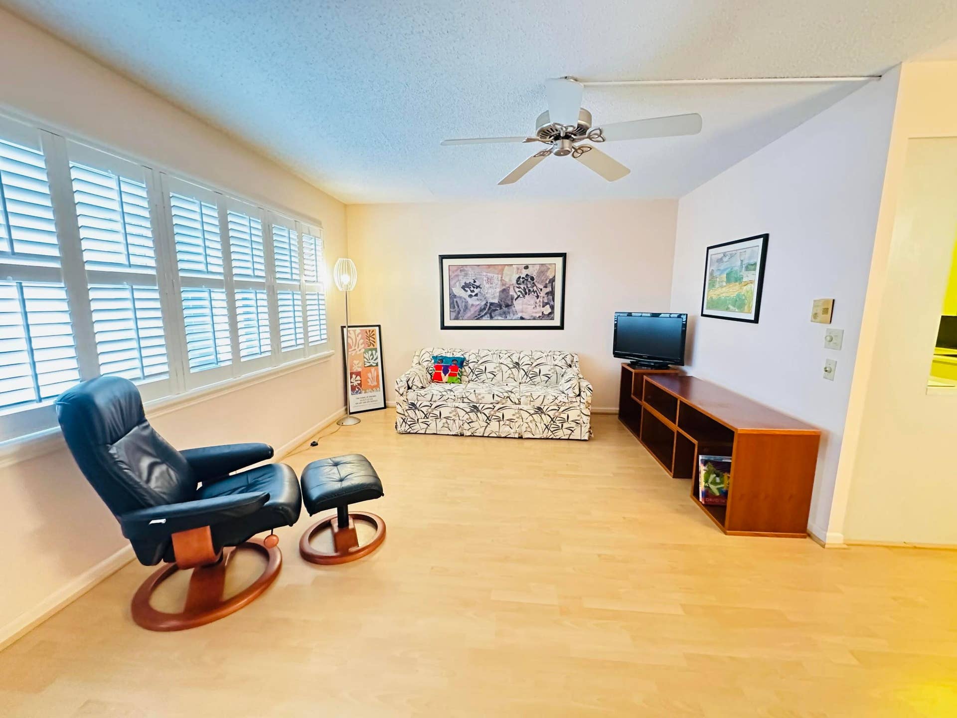 4011 NEWPORT G, Deerfield Beach, FL 33442 Interior space featuring light laminate flooring, plantation shutters, and a ceiling fan