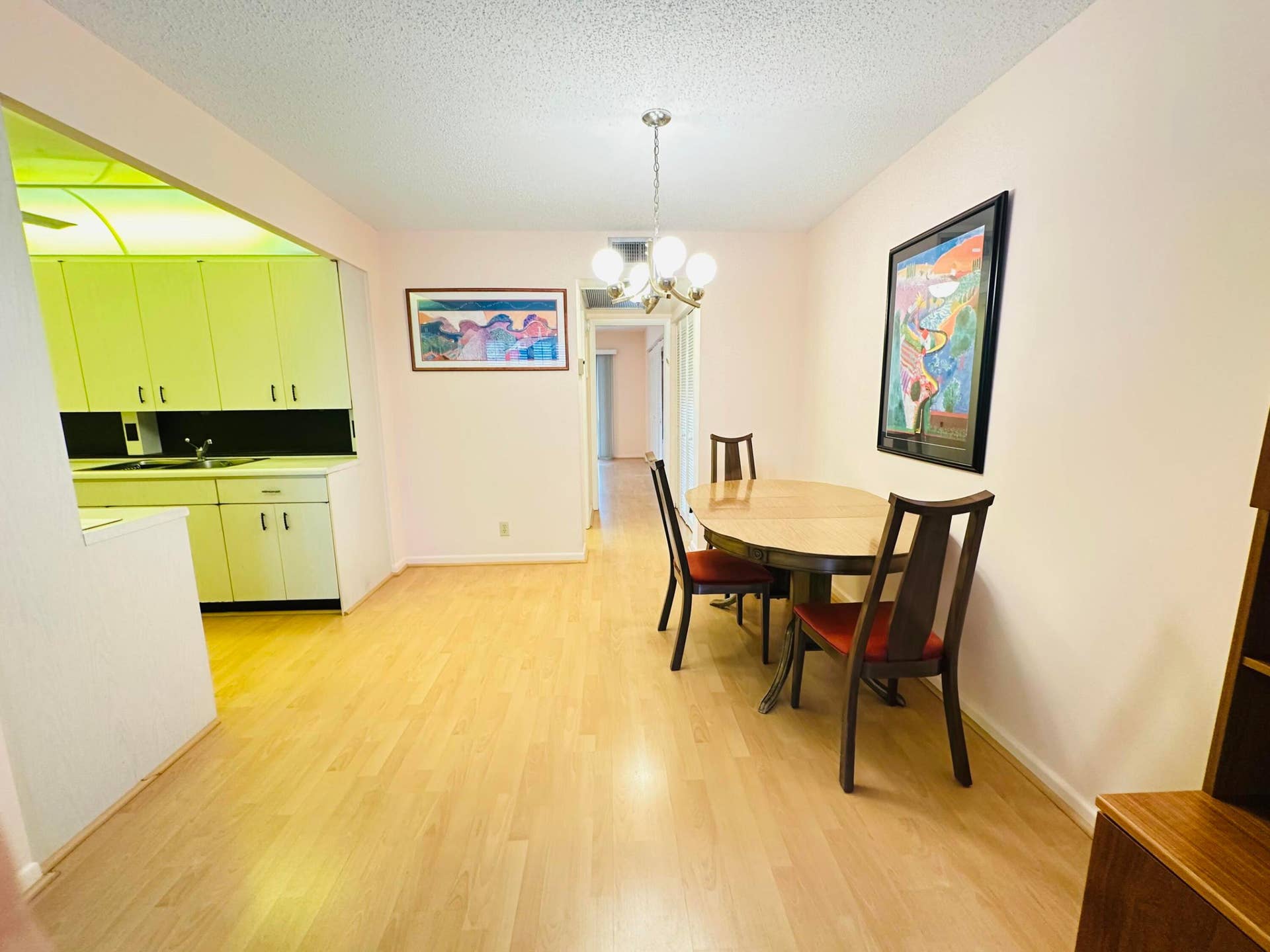 4011 NEWPORT G, Deerfield Beach, FL 33442 Dining area featuring light-toned laminate flooring and a multi-globe chandelier