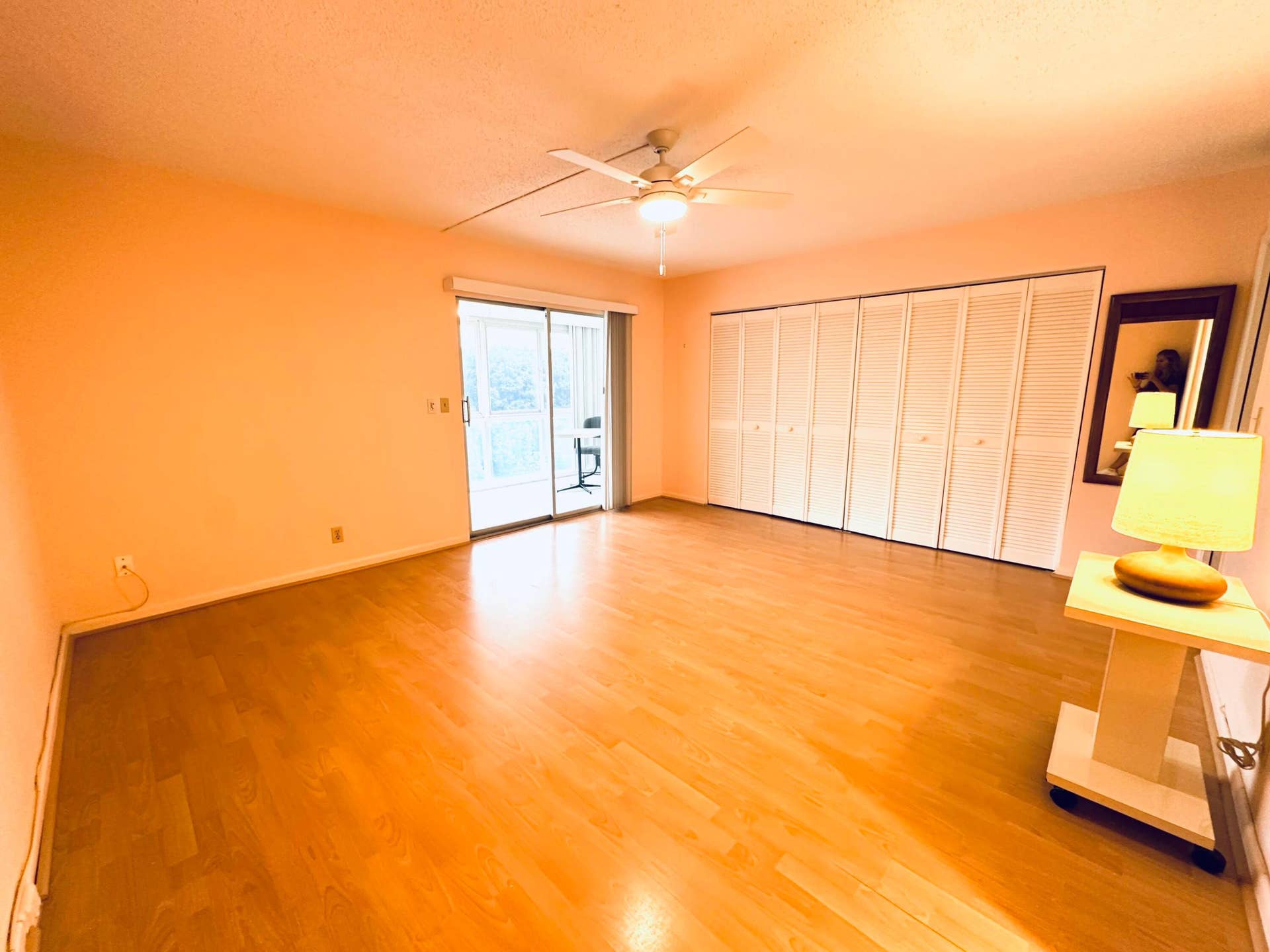 4011 NEWPORT G, Deerfield Beach, FL 33442 Spacious interior featuring wood-finish flooring, white louvered-panel closet doors, a ceiling-mounted light fixture, and a sliding glass door