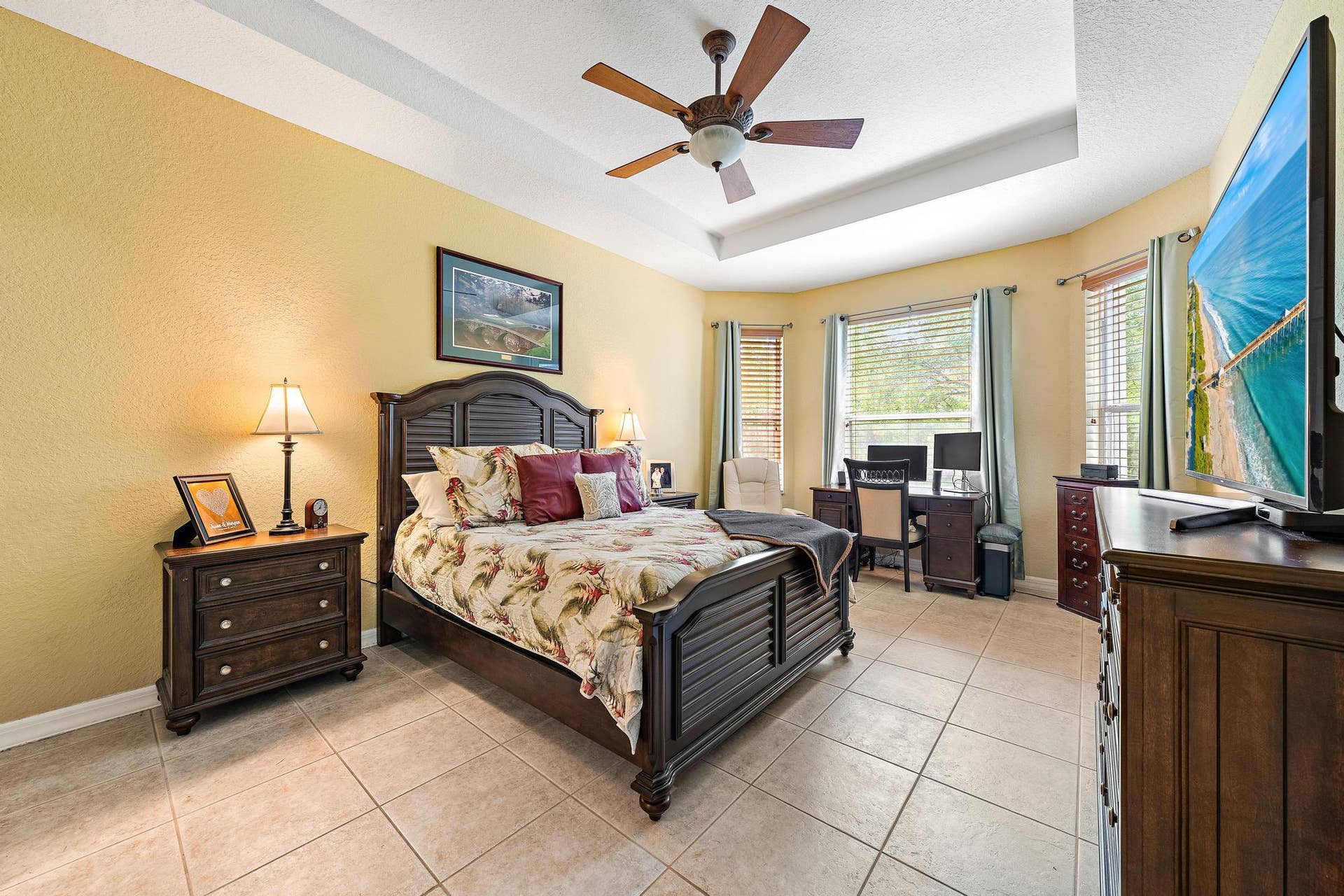 Tray ceiling, expansive tile flooring, and a bay window.
