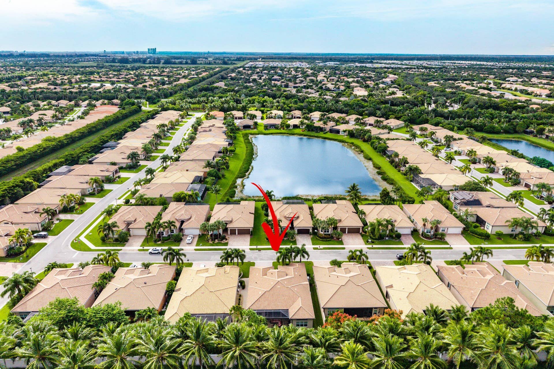 Aerial perspective of a residential property featuring a tiled roof and proximity to a central lake