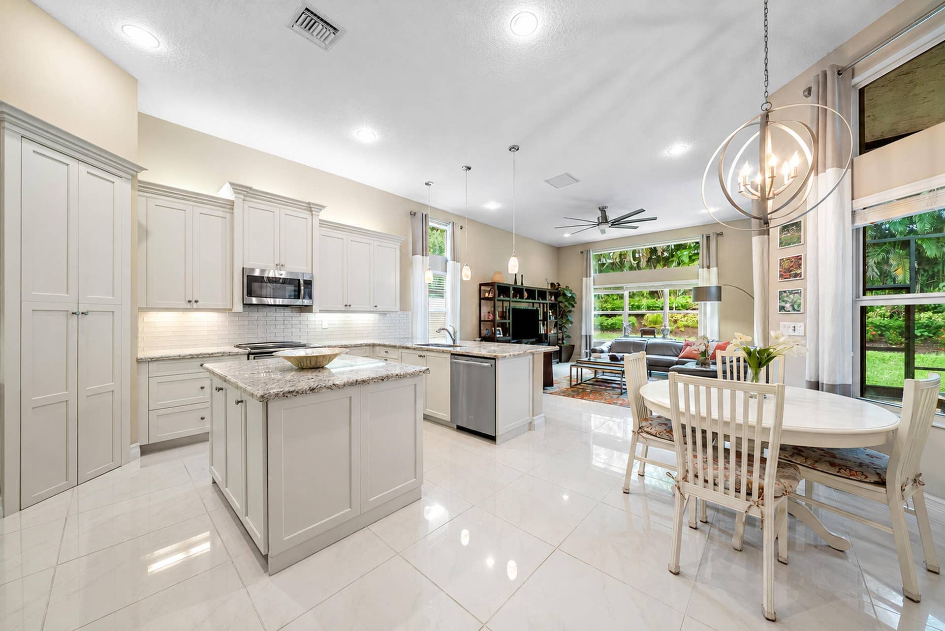 Kitchen featuring white cabinetry, stone countertops, a center island, stainless steel appliances, and tile flooring