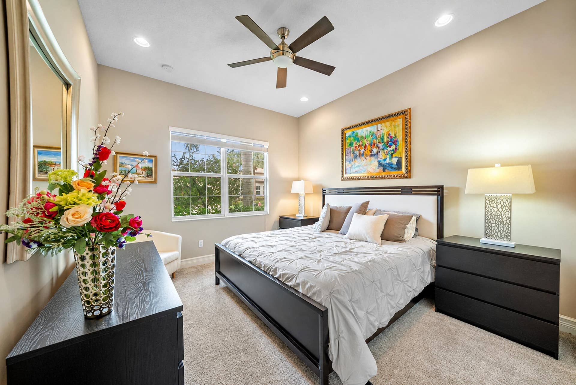 Neutral interior space featuring high ceilings, recessed lighting, a multi-blade ceiling fan, and a large grid-patterned window