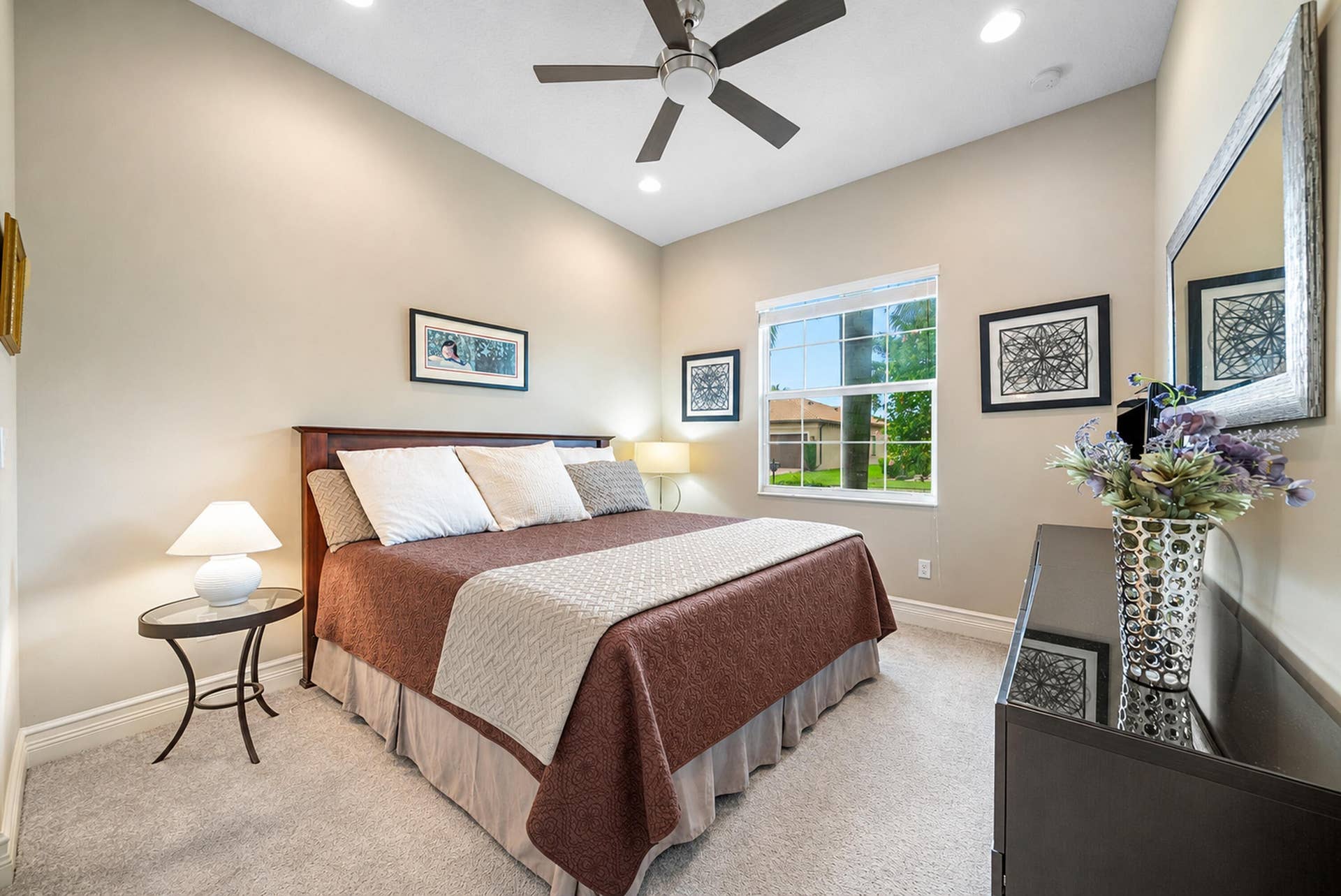 High ceilings featuring a central ceiling fan with integrated lighting, neutral wall palette, plush wall-to-wall carpeting, and a multi-pane window with exterior natural light