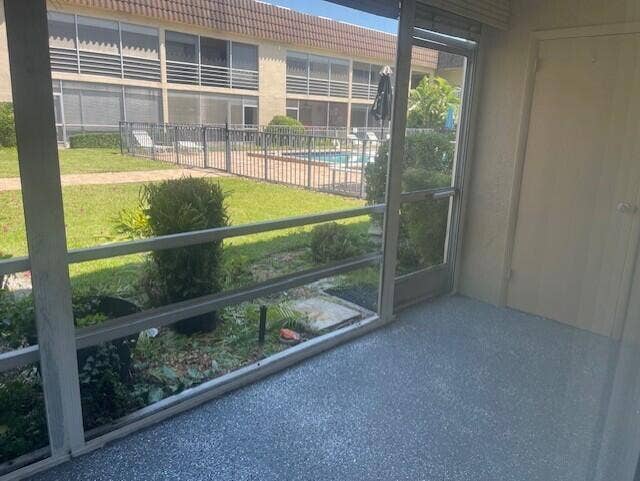 Screened-in patio featuring textured epoxy flooring and a metal-framed door