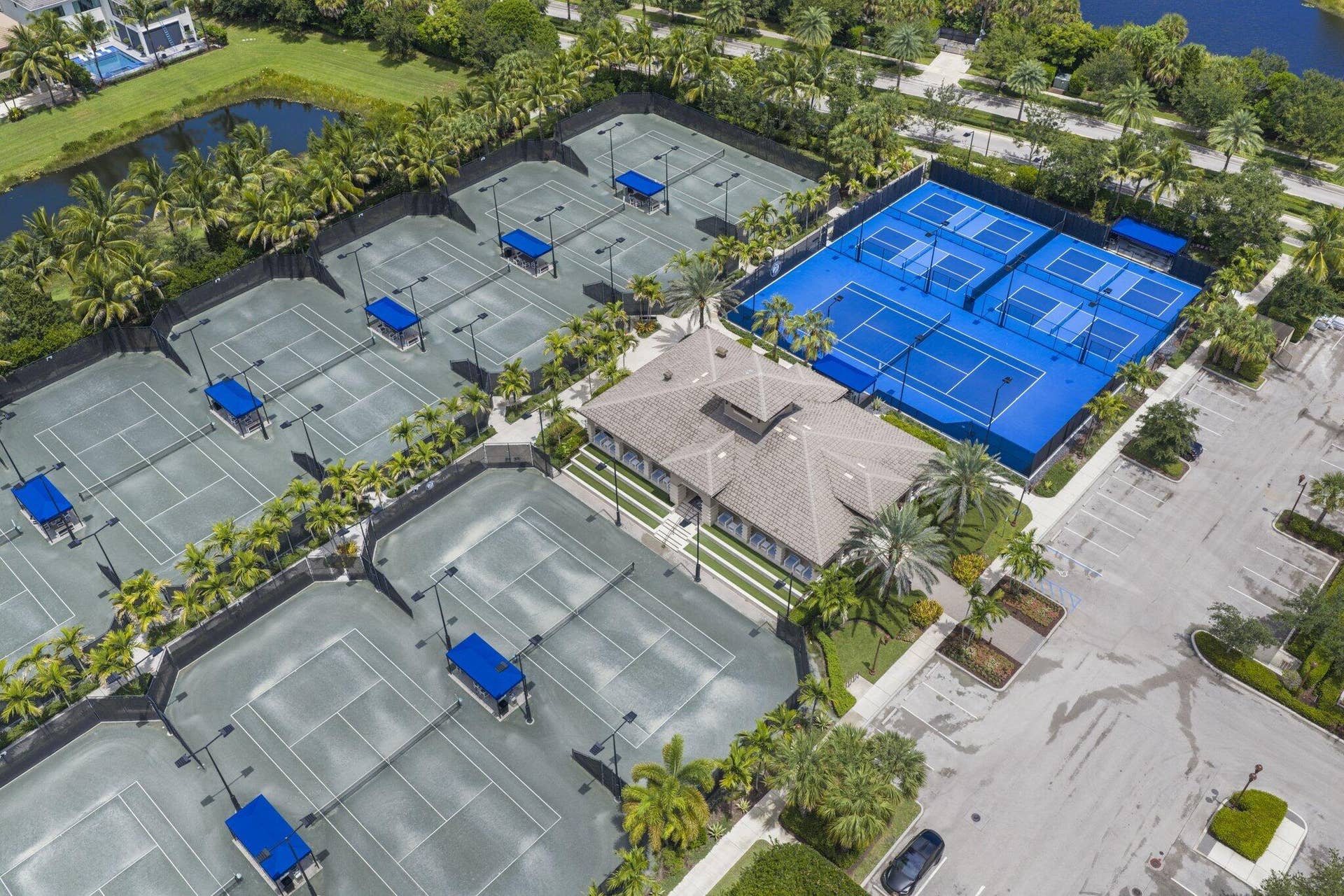 Extensive tennis court complex featuring multiple courts, a central clubhouse, and ample surrounding landscaping