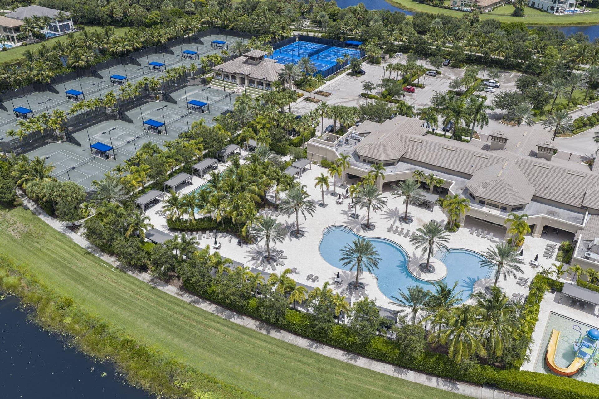 Extensive tennis courts, multiple pickleball courts, large swimming pool with integrated spa, main clubhouse building, and lush tropical landscaping