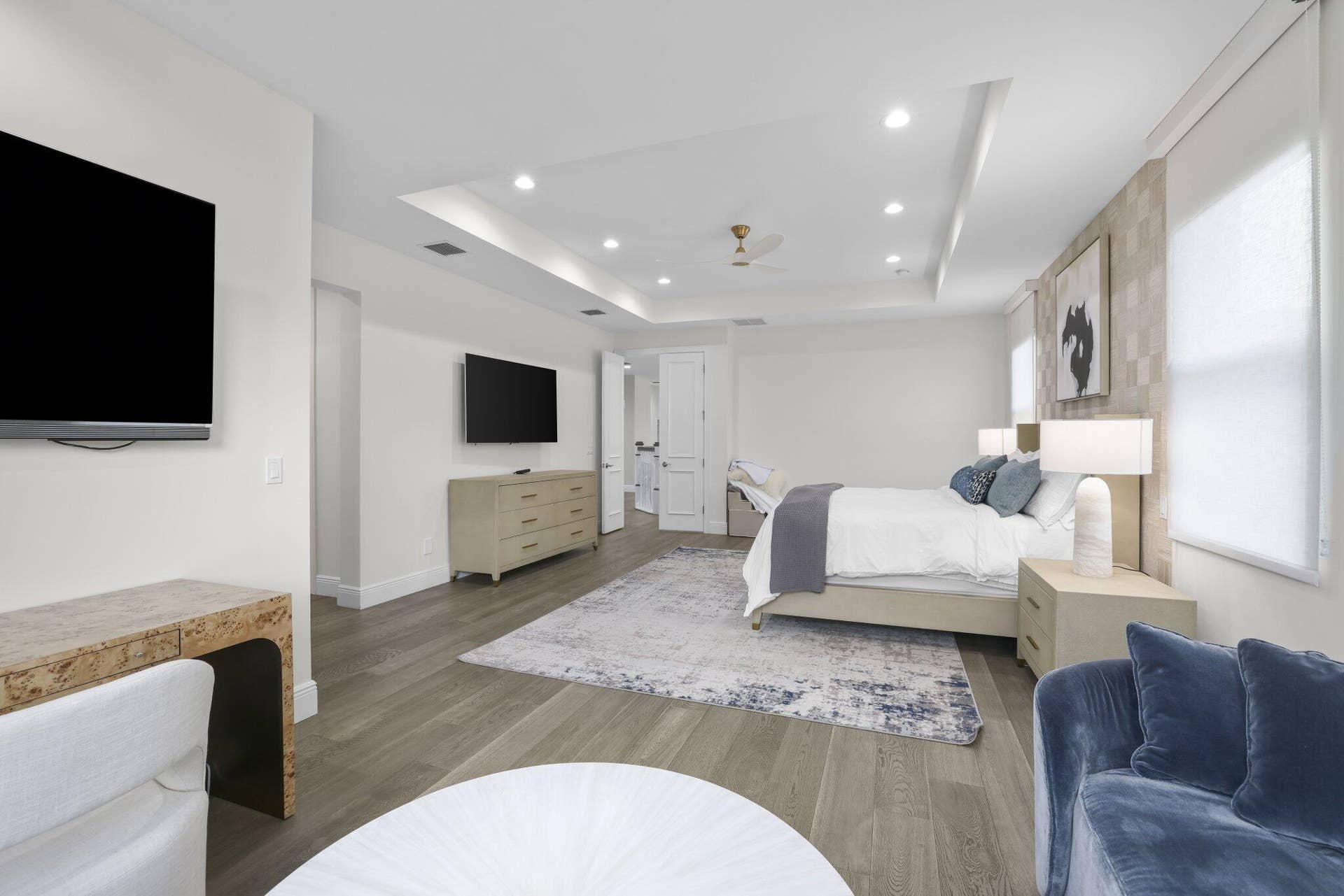Recessed lighting, tray ceiling, ceiling fan, wood-finish flooring, and white window shades