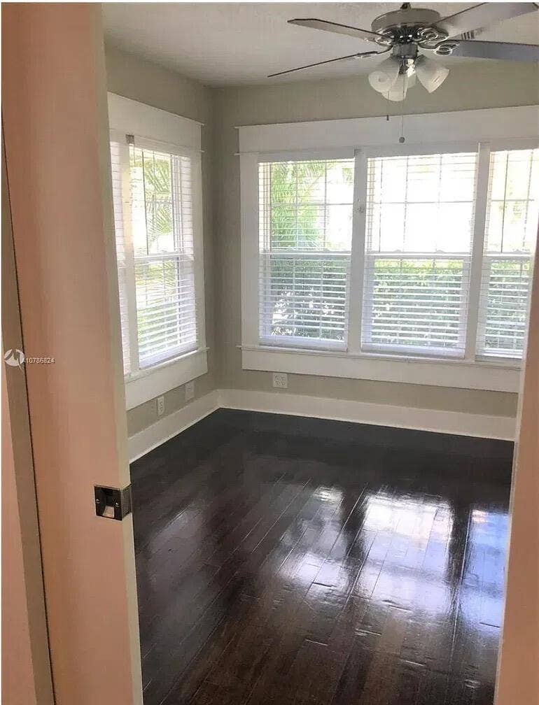 Hardwood flooring, multi-pane windows with horizontal blinds, and a ceiling fan with integrated lighting