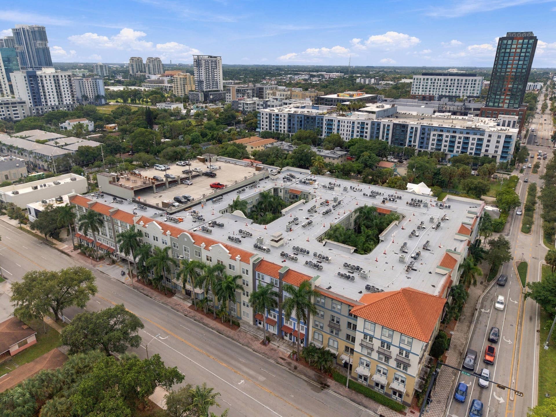 533 NE 3RD Avenue, #202, Fort Lauderdale, FL 33301 Multi-story complex featuring a terracotta-tiled roof, an interior courtyard, and an attached multi-level parking structure