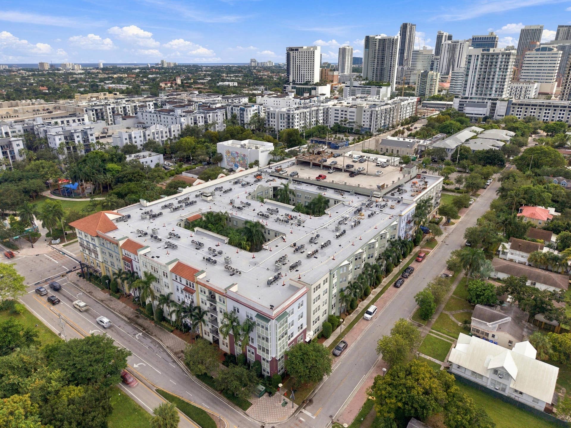 533 NE 3RD Avenue, #202, Fort Lauderdale, FL 33301 Mid-rise urban residential building featuring a central courtyard, terra cotta roof accents, multi-story masonry construction, and exterior landscaping