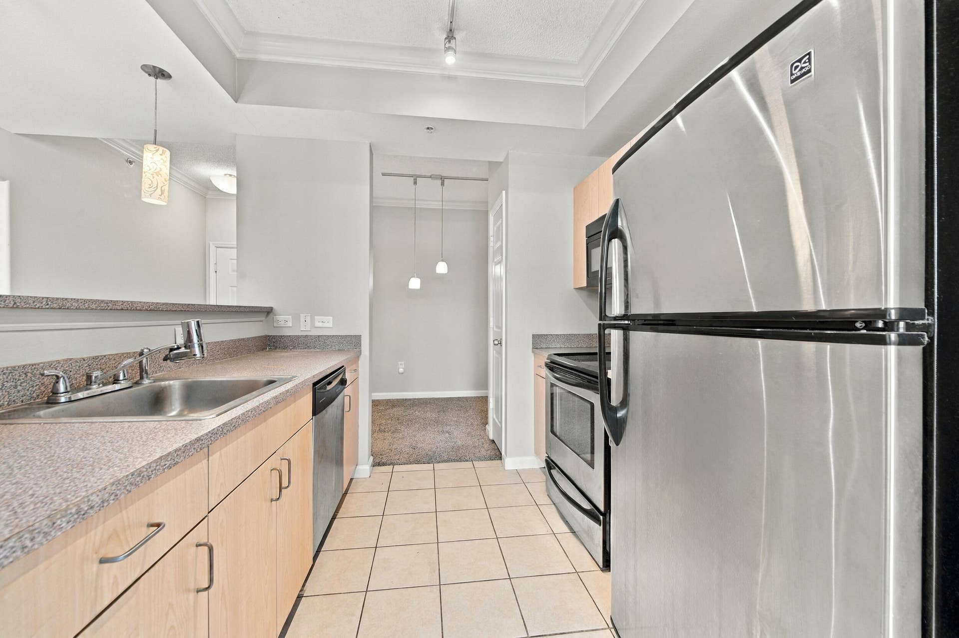 533 NE 3RD Avenue, #202, Fort Lauderdale, FL 33301 Kitchen featuring stainless steel appliances, light wood-finish cabinetry, solid surface countertops, ceramic tile flooring, and a recessed ceiling design