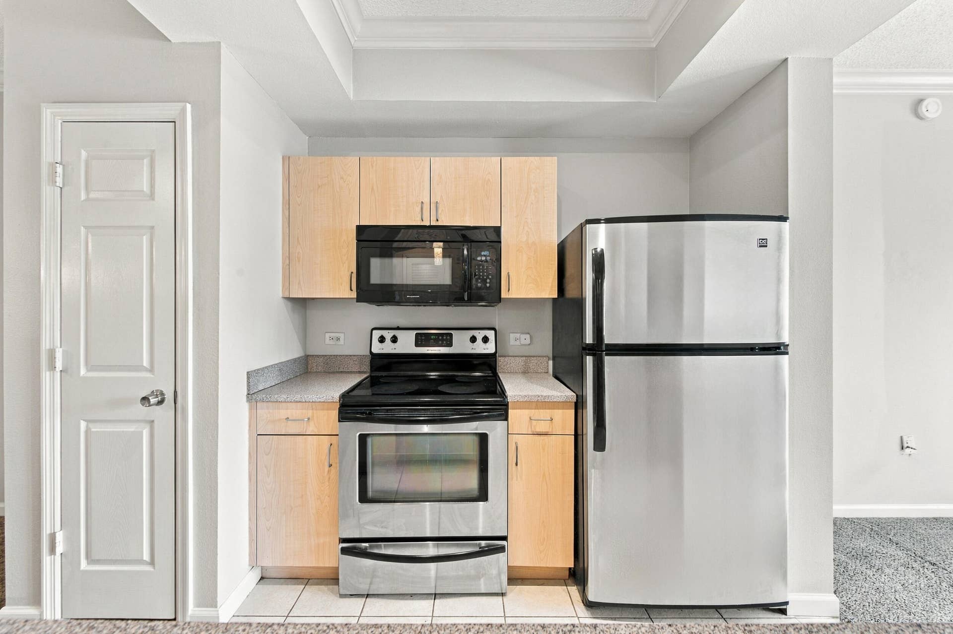 533 NE 3RD Avenue, #202, Fort Lauderdale, FL 33301 Kitchen featuring light wood-finish cabinetry, stone-texture countertops, built-in microwave, stainless steel range, and stainless steel refrigerator