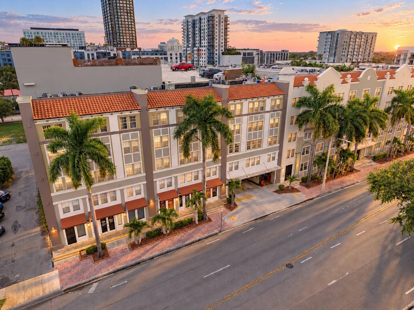 533 NE 3RD Avenue, #202, Fort Lauderdale, FL 33301 Multi-story exterior featuring terracotta roof tiles, stucco facade, decorative parapets, and integrated ground-level parking