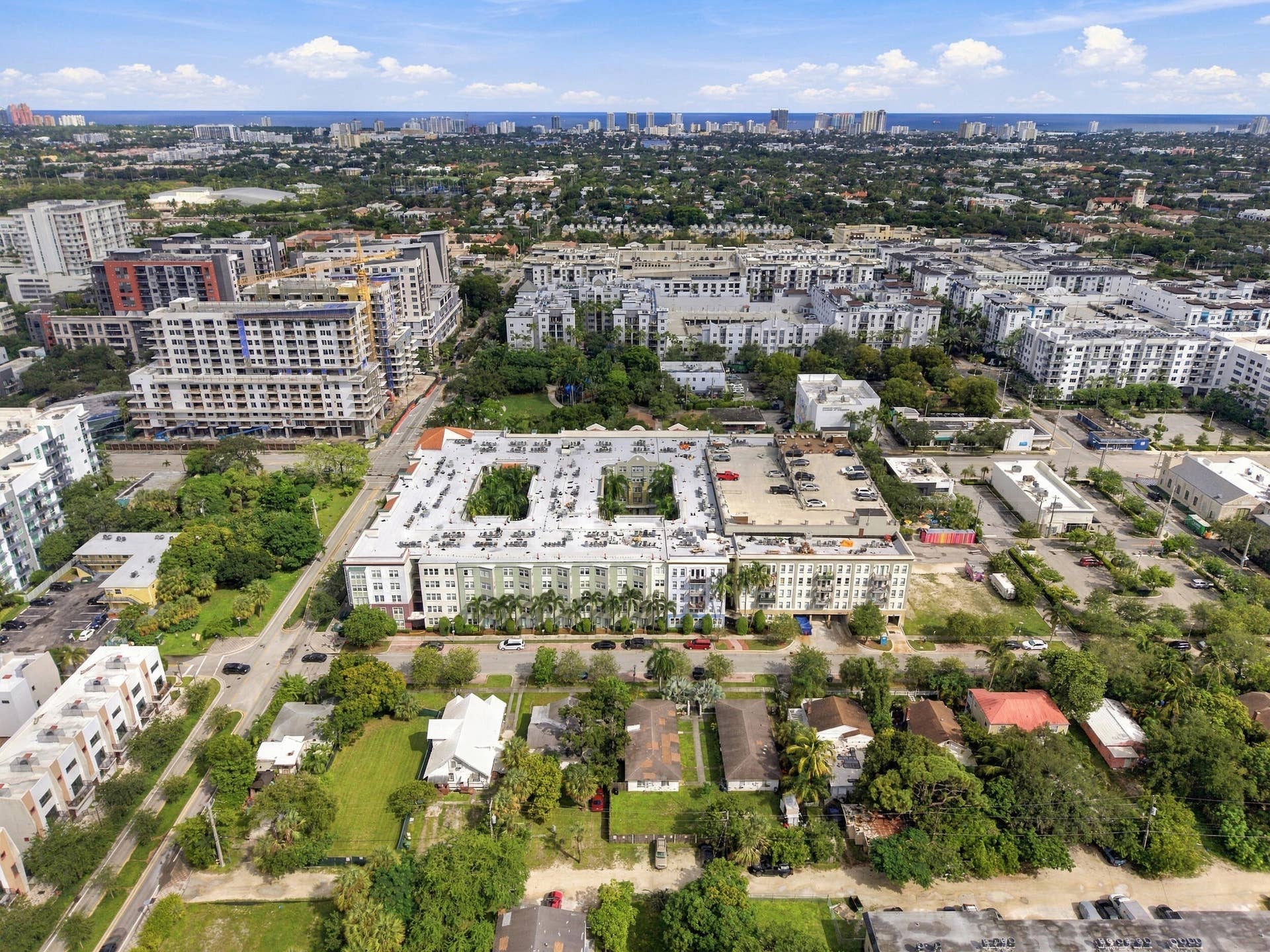 533 NE 3RD Avenue, #202, Fort Lauderdale, FL 33301 Aerial perspective of mid-rise multi-story residential building featuring dual internal courtyards, ground-level parking, and mature palm landscaping