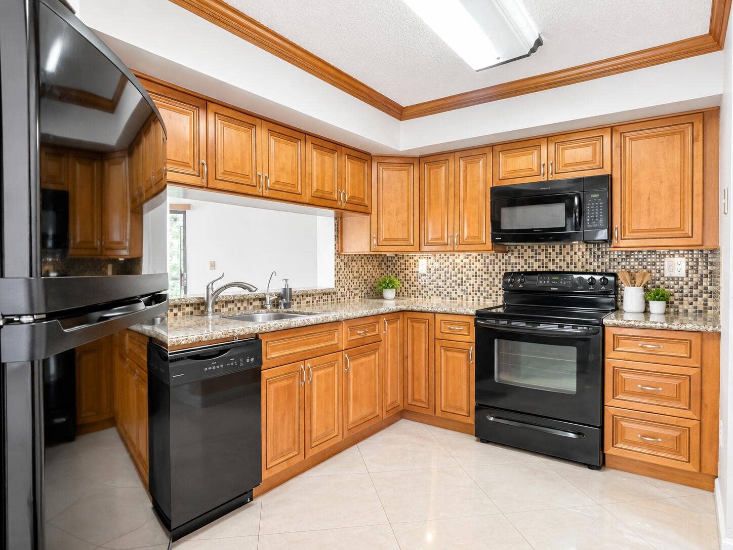 Kitchen featuring wooden cabinetry, stone-surface countertops, mosaic tile backsplash, black appliances, and tile flooring