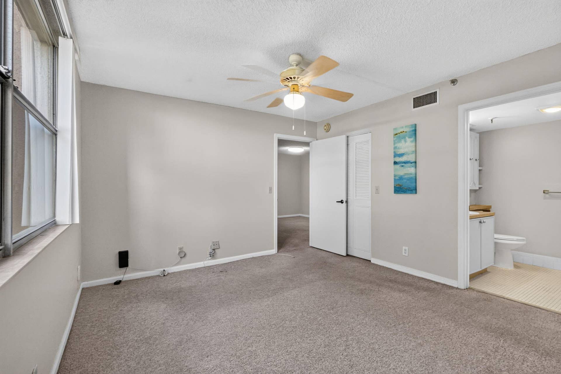 14527 BONAIRE Boulevard, #109, Delray Beach, FL 33446 Neutral-toned room featuring wall-to-wall carpeting, a ceiling fan with light fixture, and a white interior door