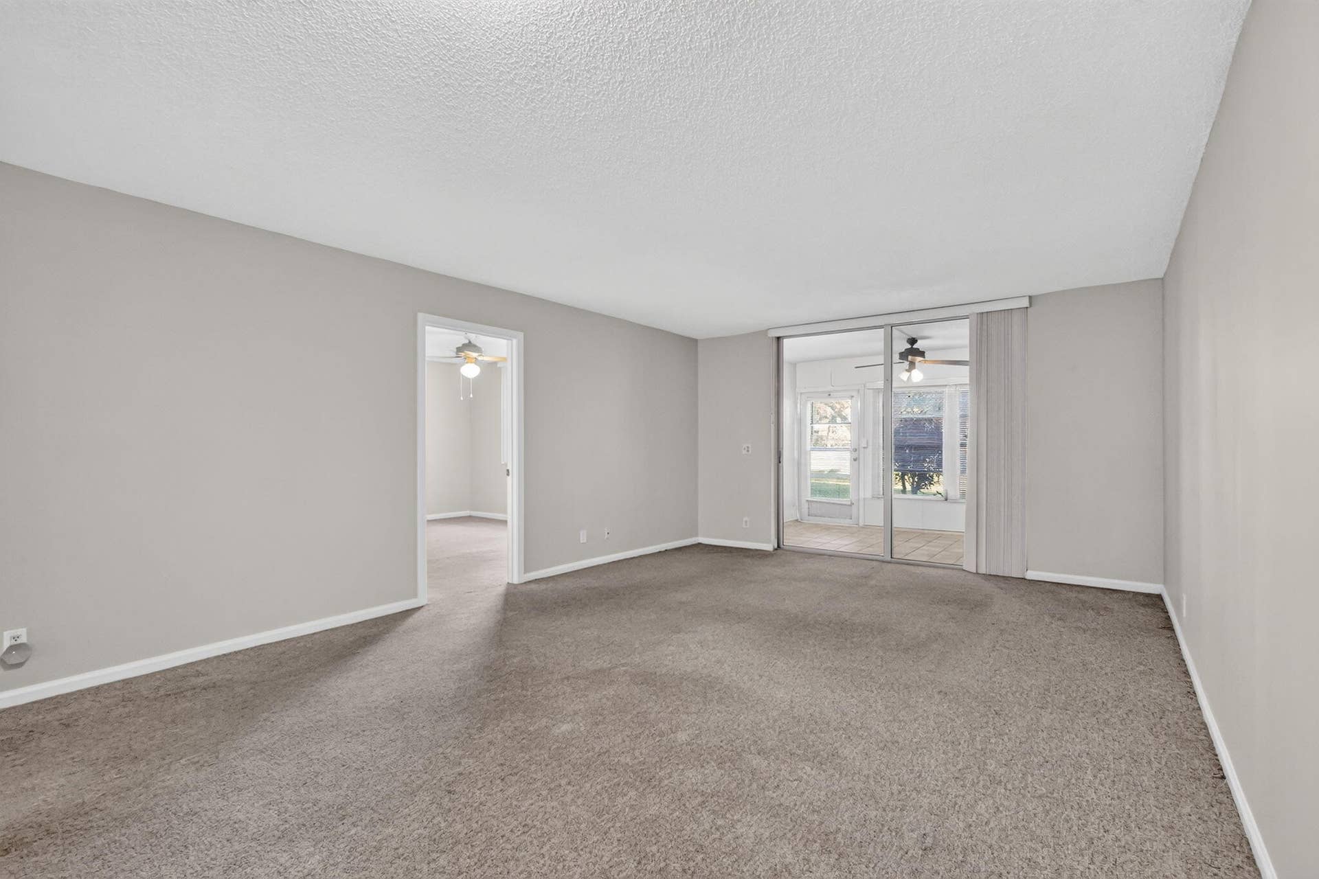 14527 BONAIRE Boulevard, #109, Delray Beach, FL 33446 Interior room featuring neutral-toned carpeting, textured ceiling finish, and sliding glass doors
