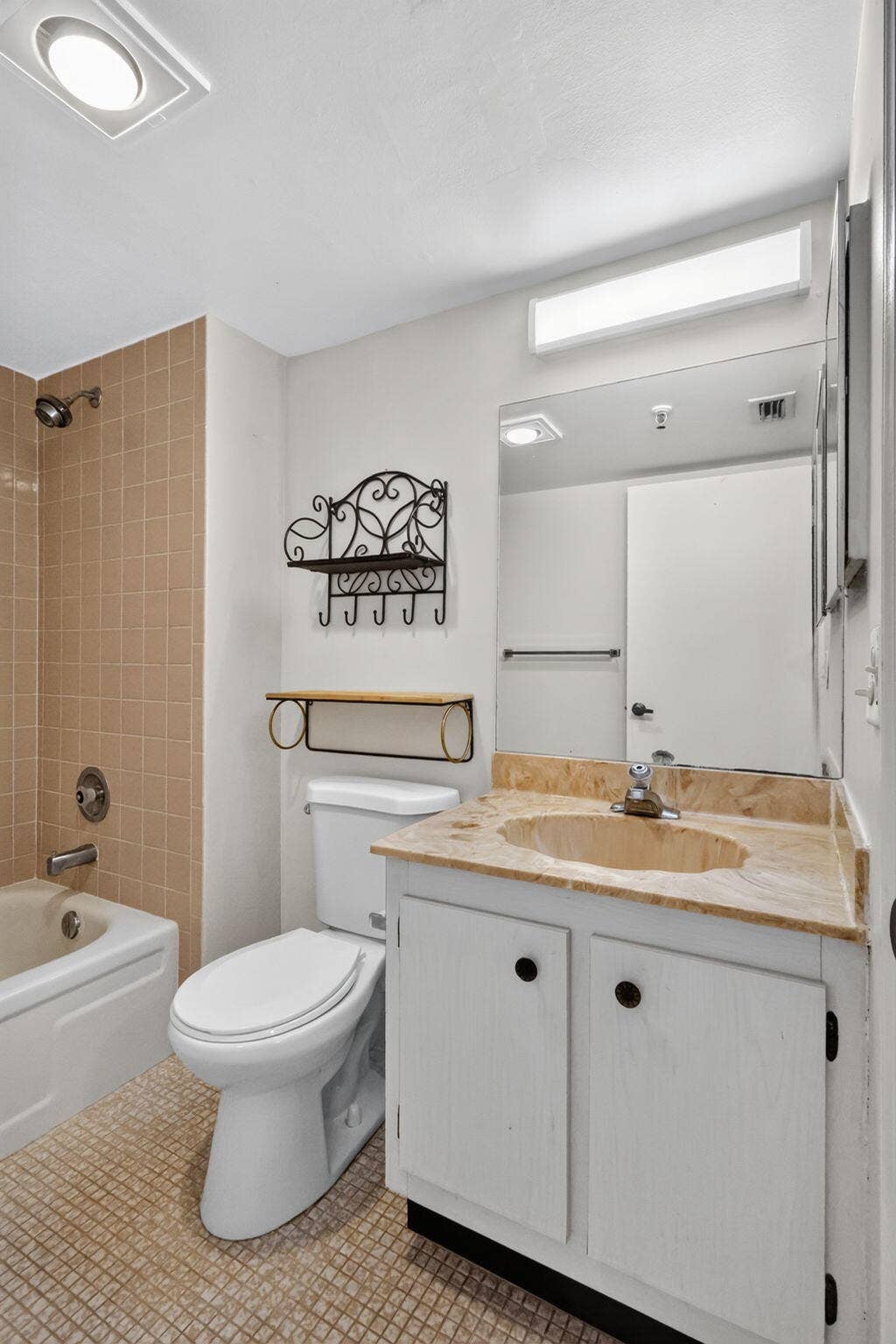 14527 BONAIRE Boulevard, #109, Delray Beach, FL 33446 Bathroom featuring a vanity with stone-surfaced countertop, integrated sink, tiled tub surround, full-width mirror, and overhead lighting