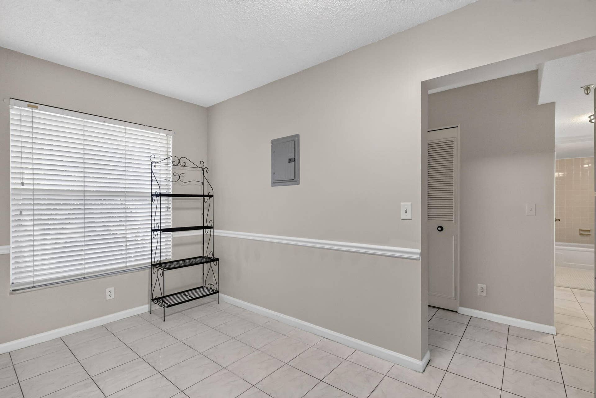 14527 BONAIRE Boulevard, #109, Delray Beach, FL 33446 Neutral-toned interior featuring ceramic tile flooring, horizontal window blinds, chair rail molding, and a louvered closet door