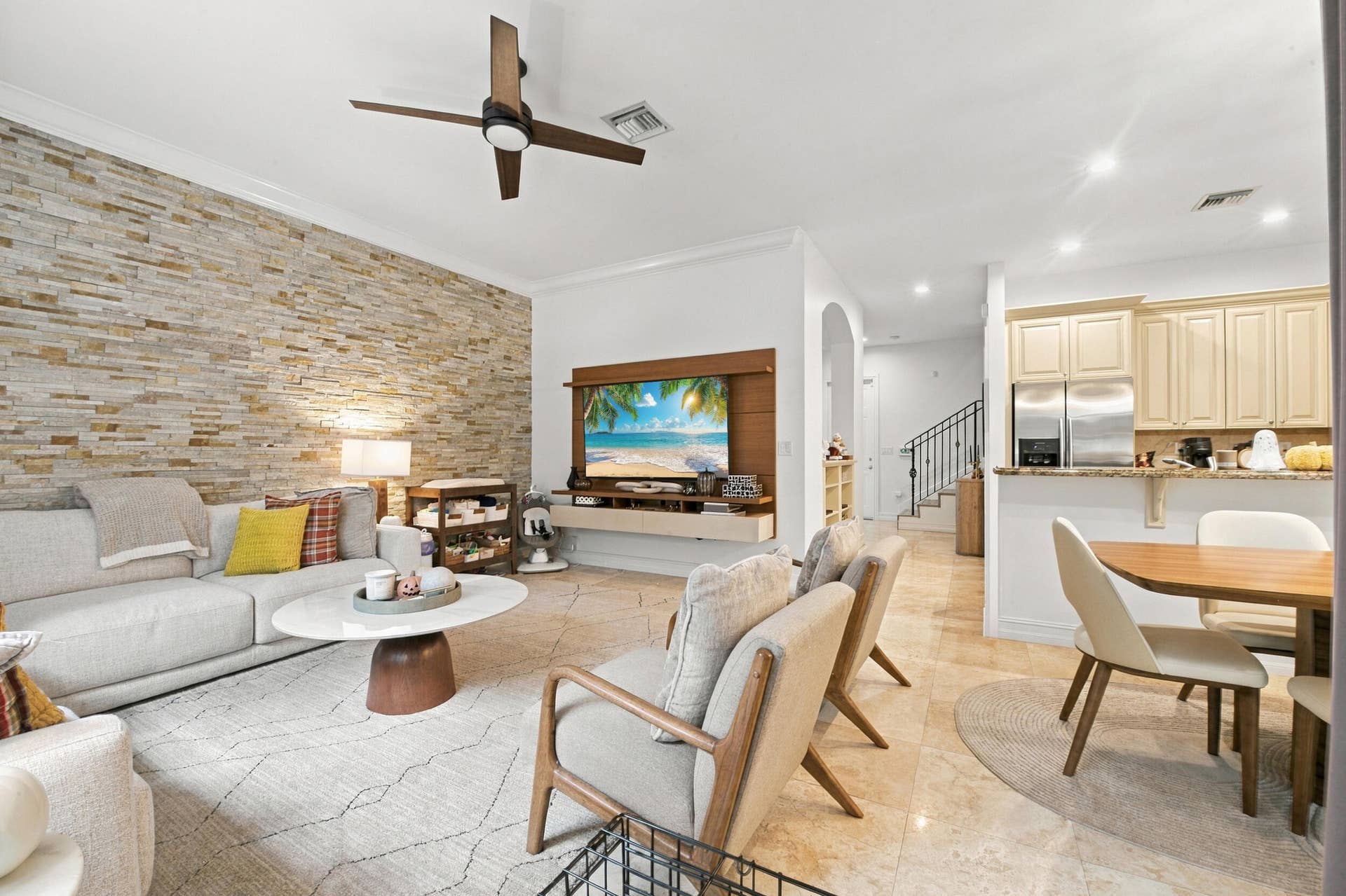 1752 NE 12TH Street, Fort Lauderdale, FL 33304 Living area featuring a stacked stone accent wall, tile flooring, built-in wooden media console, recessed lighting, and a ceiling fan