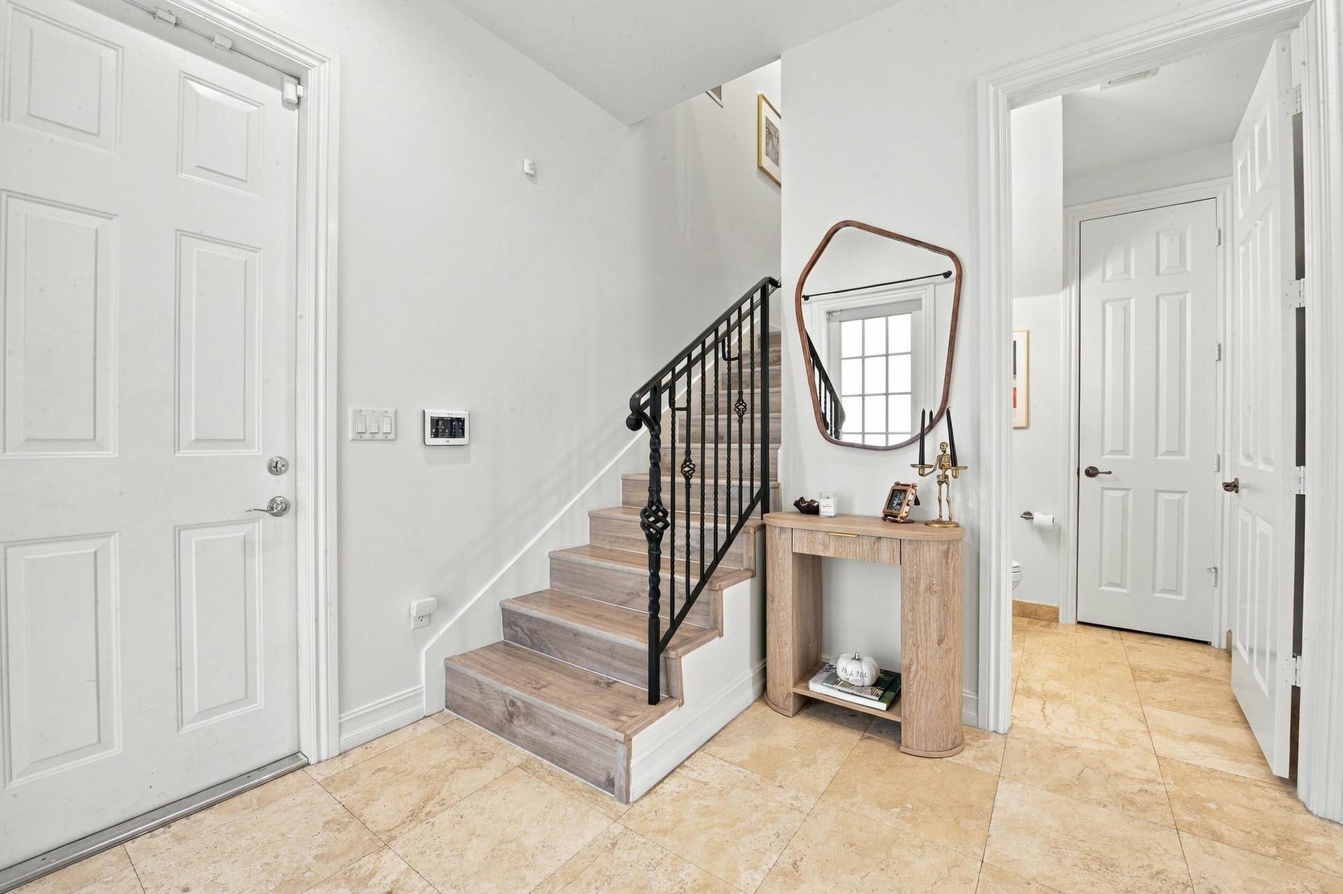 1752 NE 12TH Street, Fort Lauderdale, FL 33304 Entryway featuring large-format tile flooring, staircase with wood-finish treads, and black iron balustrade