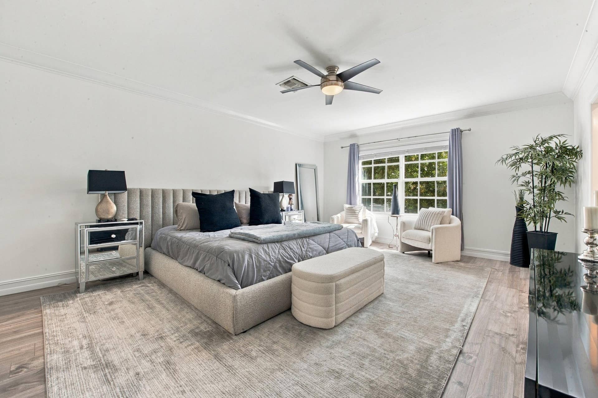 1752 NE 12TH Street, Fort Lauderdale, FL 33304 Bedroom featuring wood-finish flooring, multi-pane window, crown molding, and a central ceiling fan with integrated lighting