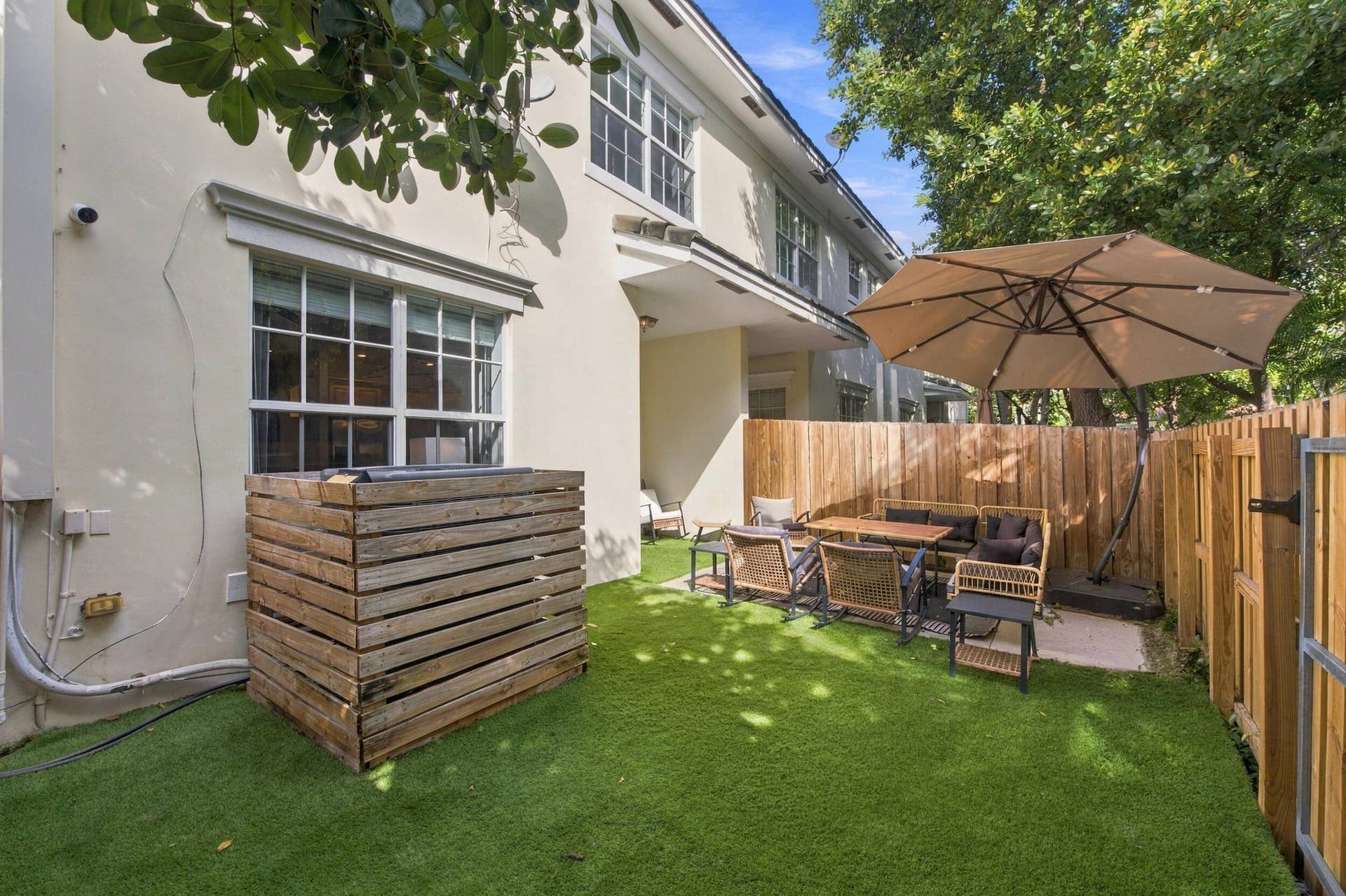 1752 NE 12TH Street, Fort Lauderdale, FL 33304 Private fenced backyard featuring low-maintenance synthetic turf and a paved patio area