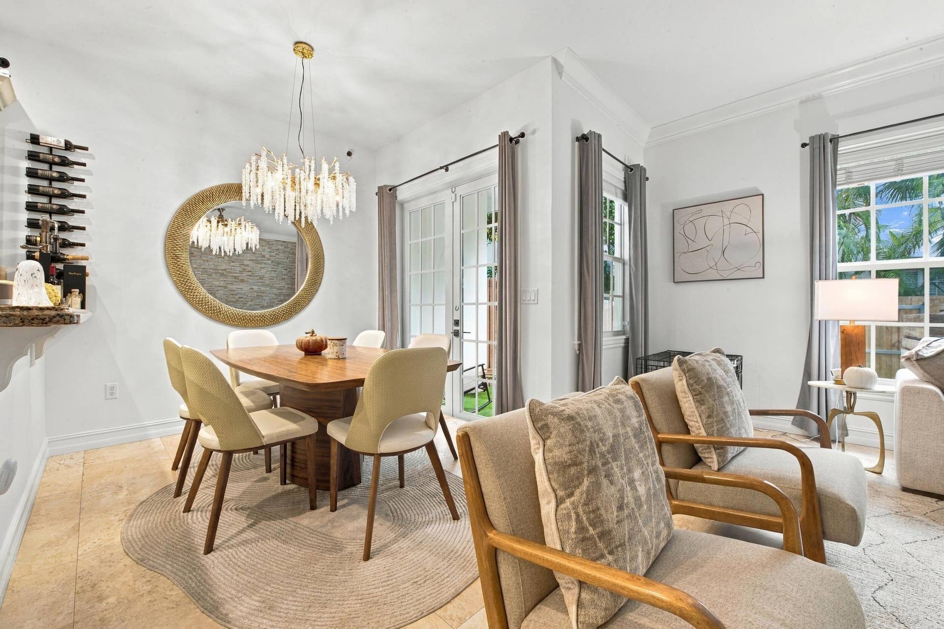 1752 NE 12TH Street, Fort Lauderdale, FL 33304 Dining area featuring neutral stone flooring, crown molding, a multi-tiered crystal chandelier, and glass-paned French doors