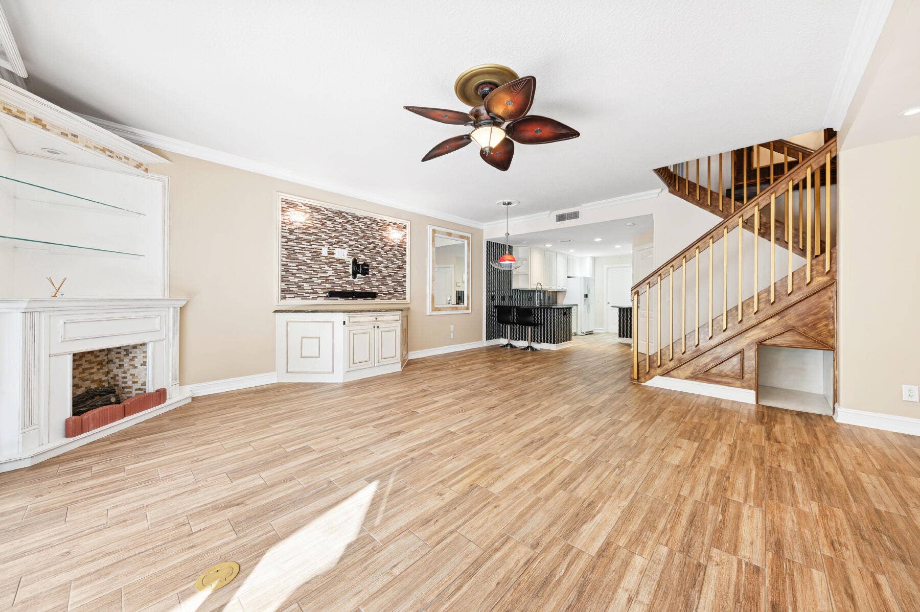 477 Capistrano Drive, Palm Beach Gardens, Palm Beach Gardens, FL 33410 Wood-finish flooring, fireplace with stone-tile surround, custom built-in cabinetry, decorative ceiling fan, and wooden staircase with metal balusters