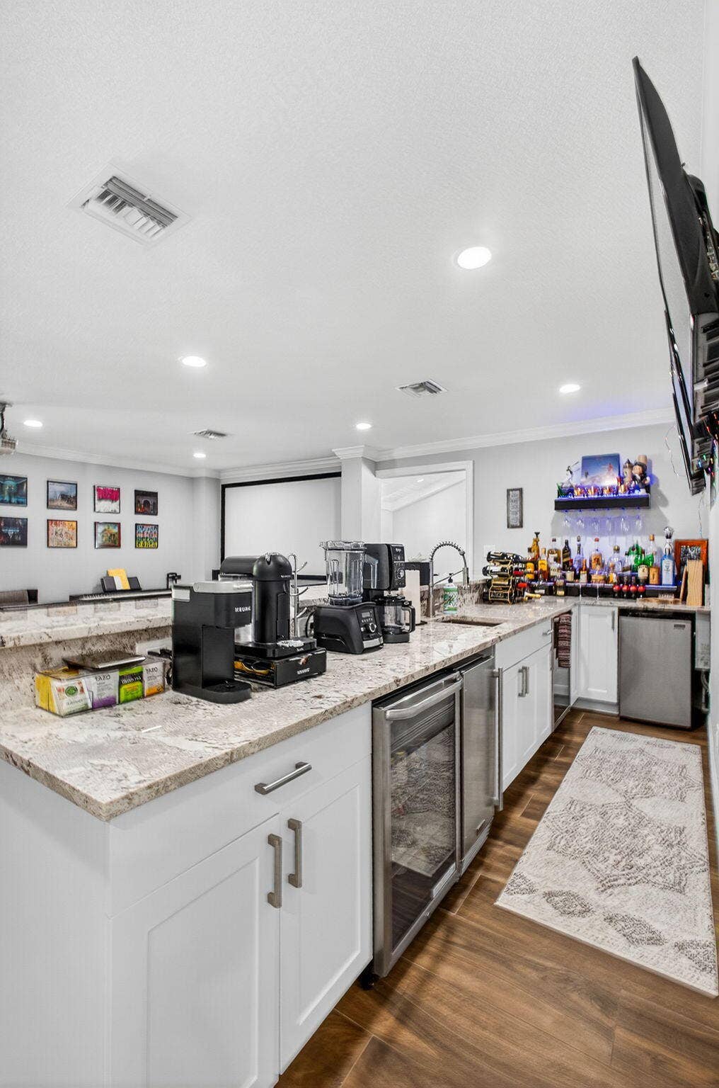 4628 Square Lake Drive, Palm Beach Gardens, FL 33418 Wet bar featuring white cabinetry, stone countertops, stainless steel under-counter appliances, recessed lighting, and wood-finish flooring