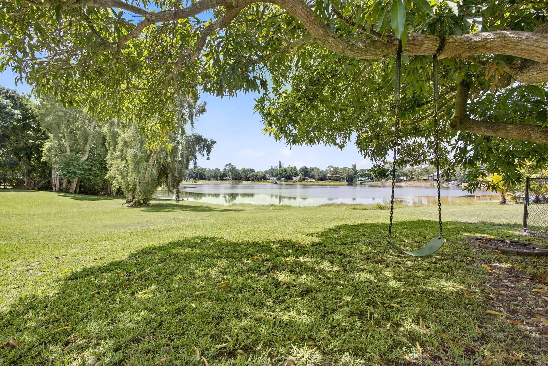4628 Square Lake Drive, Palm Beach Gardens, FL 33418 Expansive lawn featuring mature trees and a waterfront border